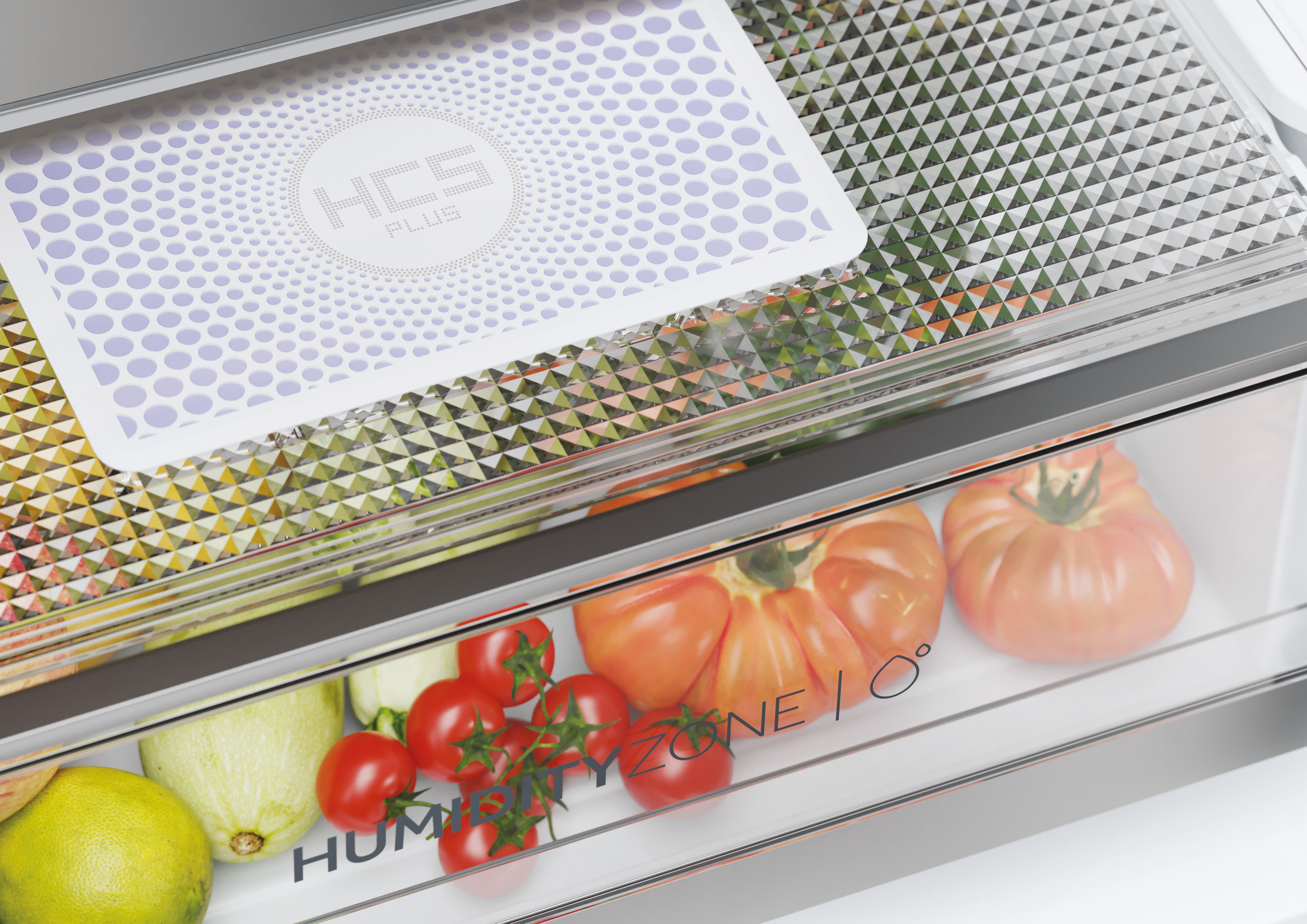 Interno frigorifero: cassetto verdura con verdure, pomodori ed etichetta bianca HCS PLUS.