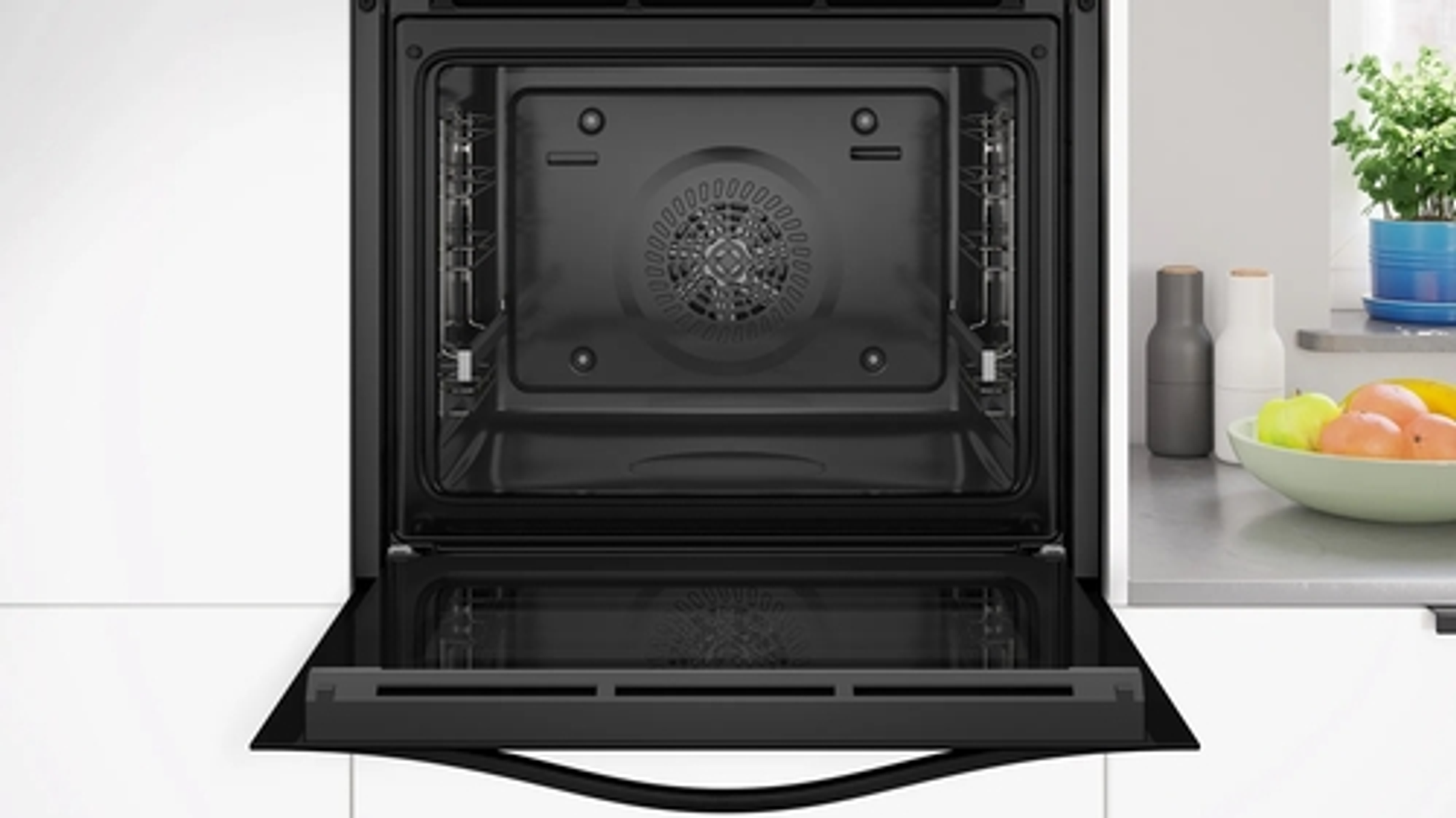 Un forno aperto con un vassoio e una ventola. Il forno è nero e lo sfondo è bianco.