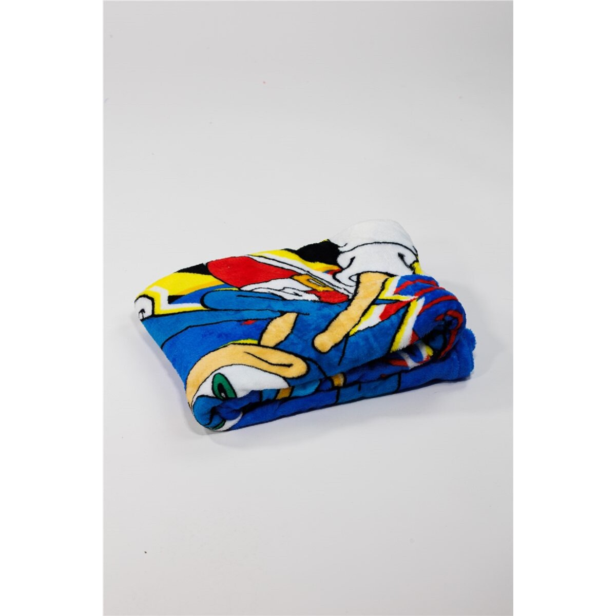 Eine gefaltete blaue Decke mit einem Sonic the Hedgehog-Design. Sie ist gefaltet und auf einer weißen Oberfläche platziert.