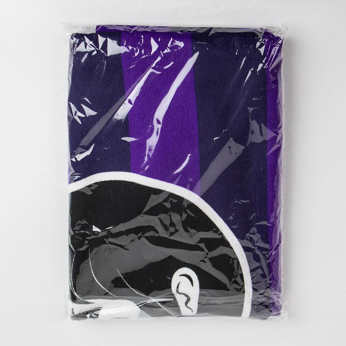 Una toalla envuelta con un patrón morado y blanco y la cara de un personaje visible.