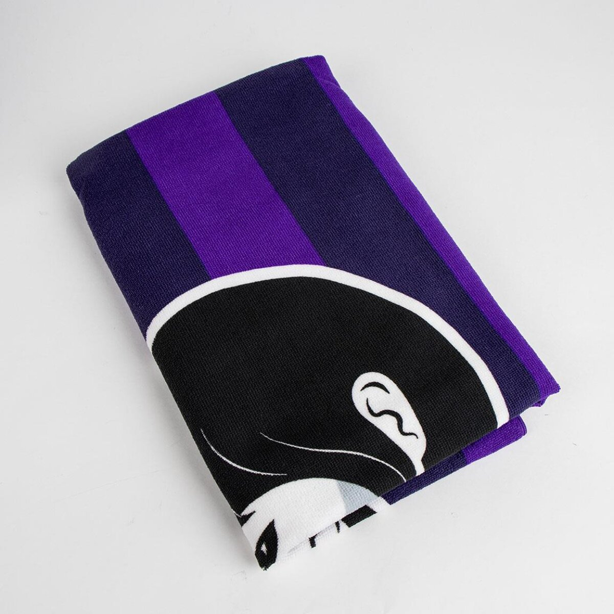 Una toalla doblada con un patrón morado y blanco, con la cara de un personaje de dibujos animados.