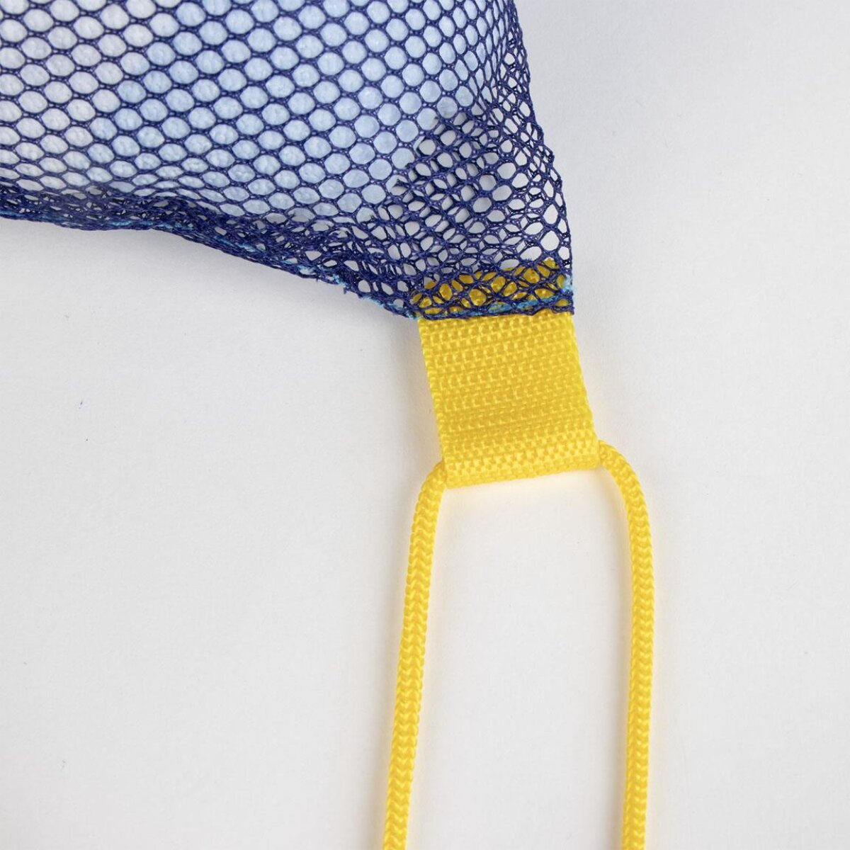 Primer plano de una bolsa de malla azul con correa y lazo amarillos, sobre fondo blanco.