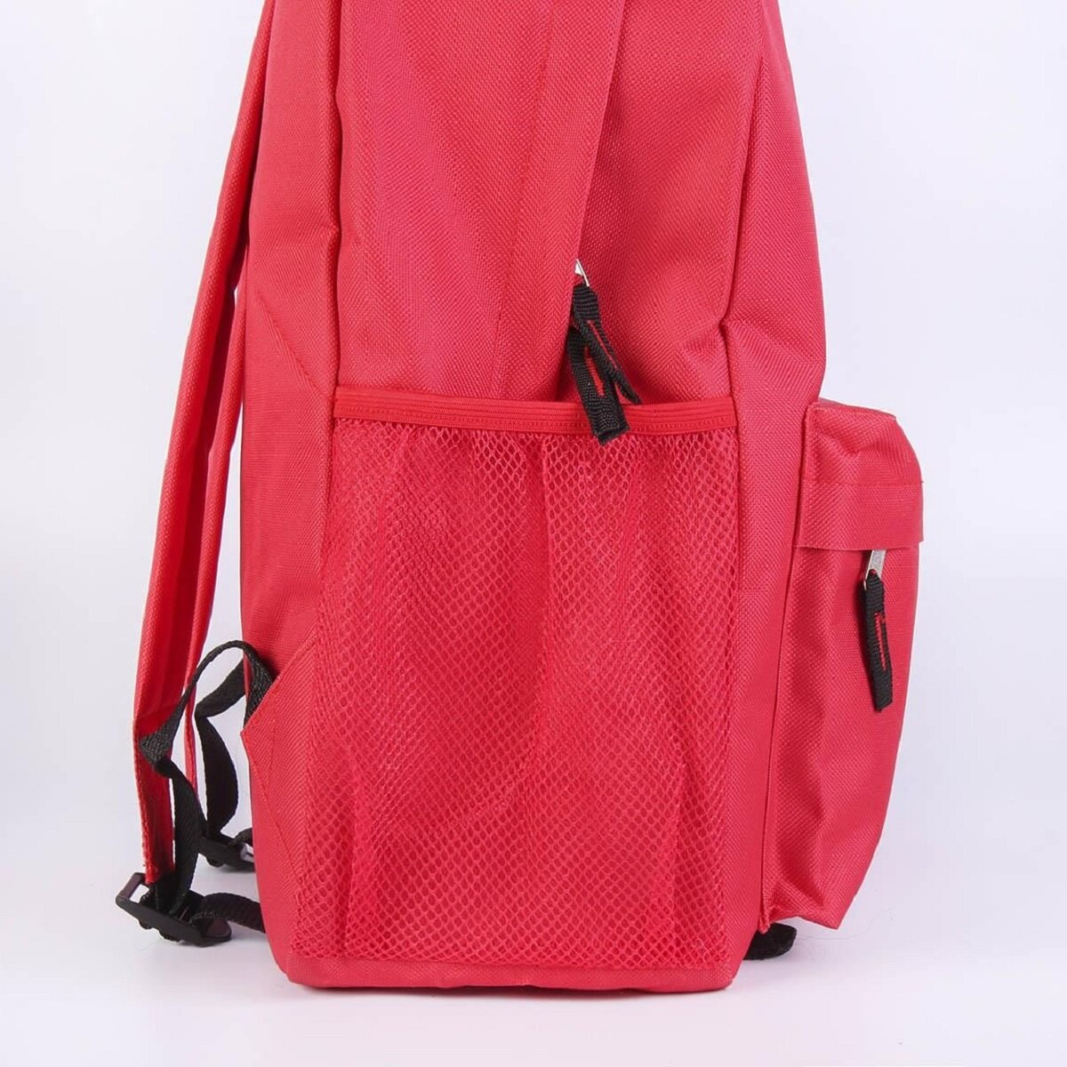 Mochila roja con bolsillo de malla lateral y correas negras.