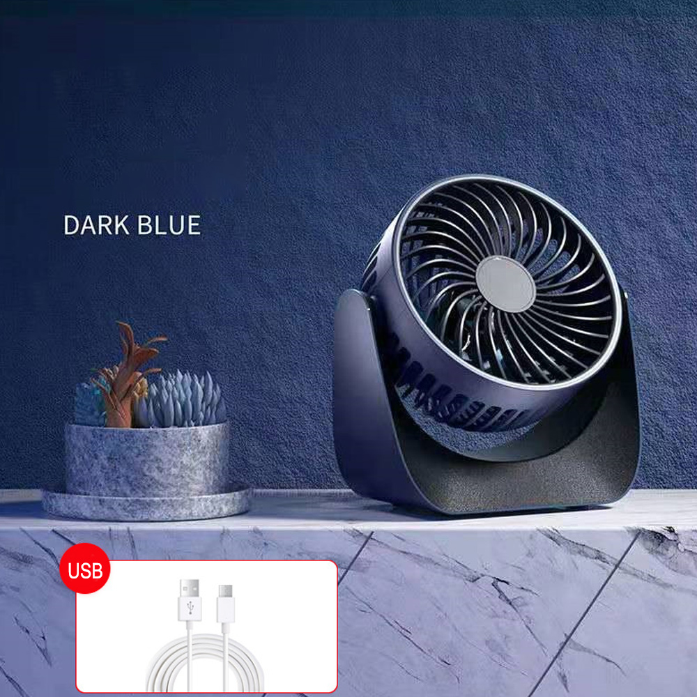 Dunkelblauer Schreibtischventilator, Sukkulenten und USB-Kabel auf Marmor.