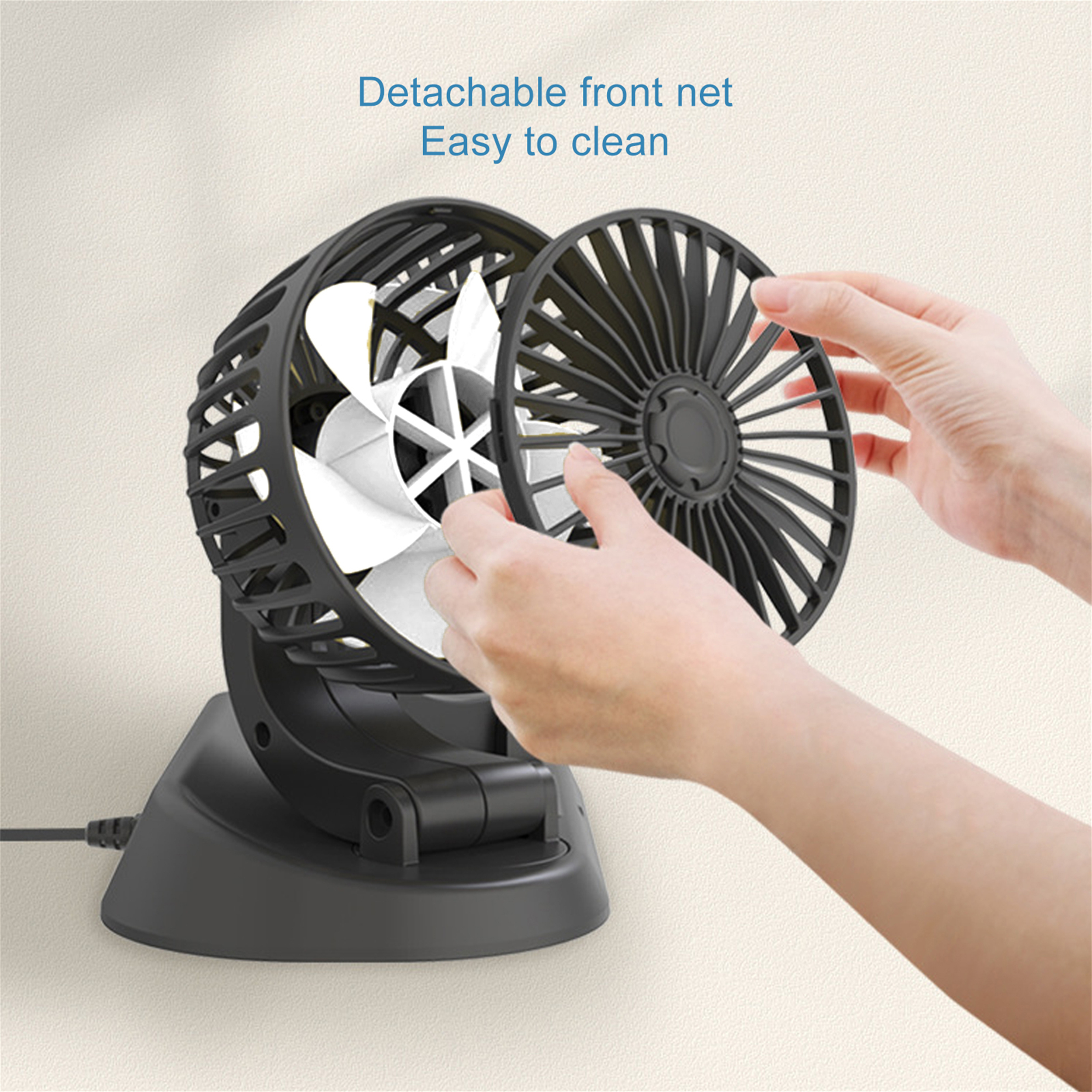 Eine Person entfernt das vordere Netz von einem schwarzen Ventilator. Die Flügel sind weiß.