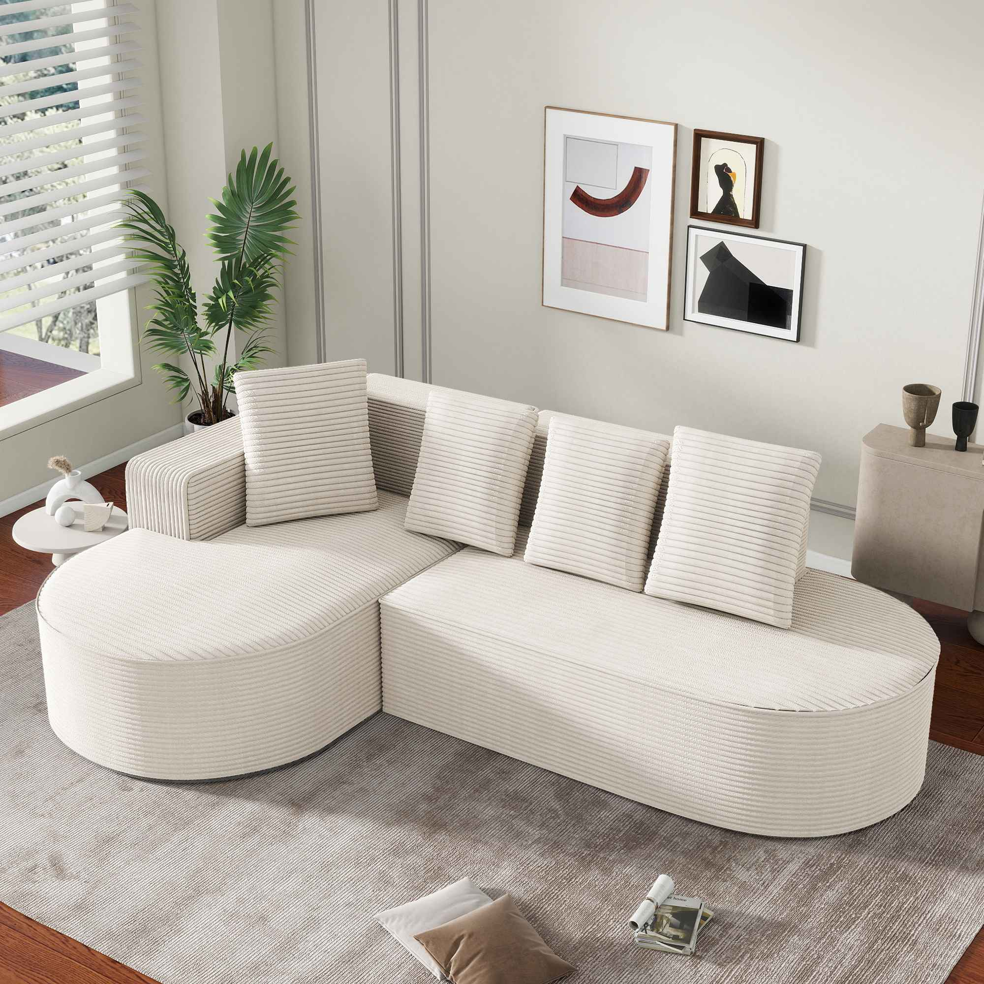 Ein geschwungenes cremefarbenes Sofa mit Kissen, in einem Raum mit Kunst und einem Teppich.