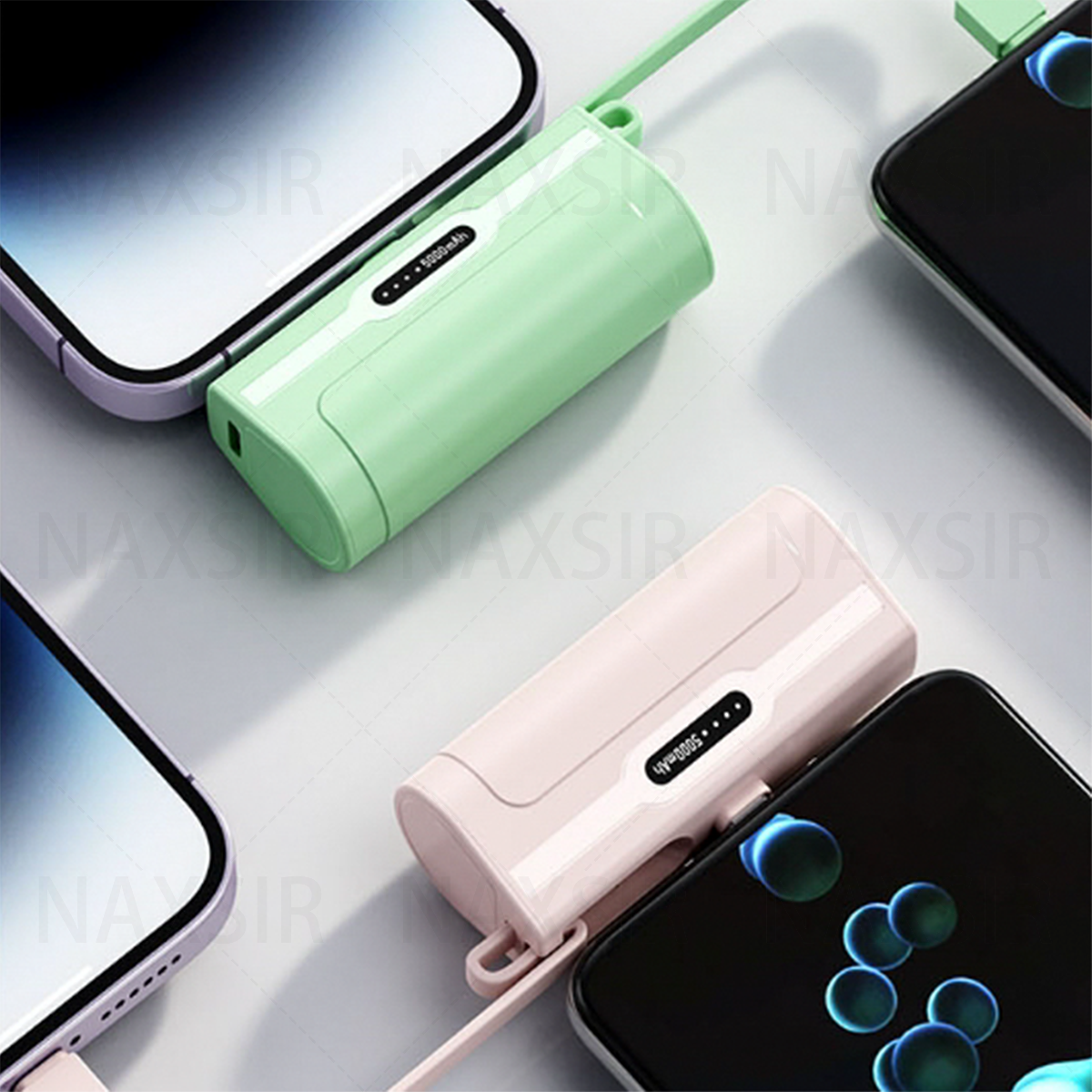 Zwei Powerbanks und zwei Telefone. Eine Powerbank ist grün, die andere rosa, beide mit Display.