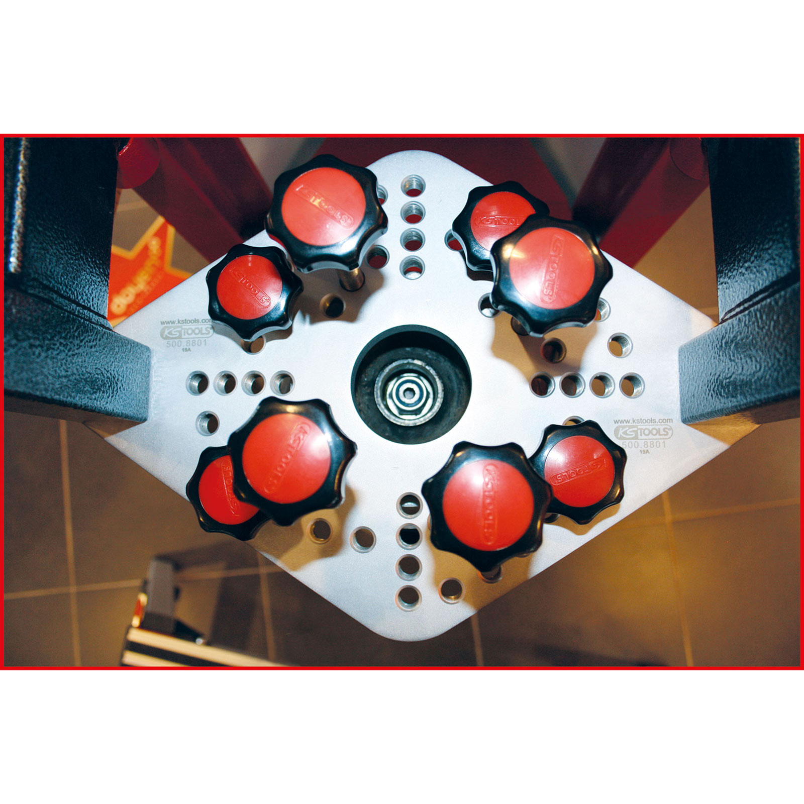 Nahaufnahme einer silbernen Platte mit roten Knöpfen und Gewindestangen. Die Platte hat viele Löcher.