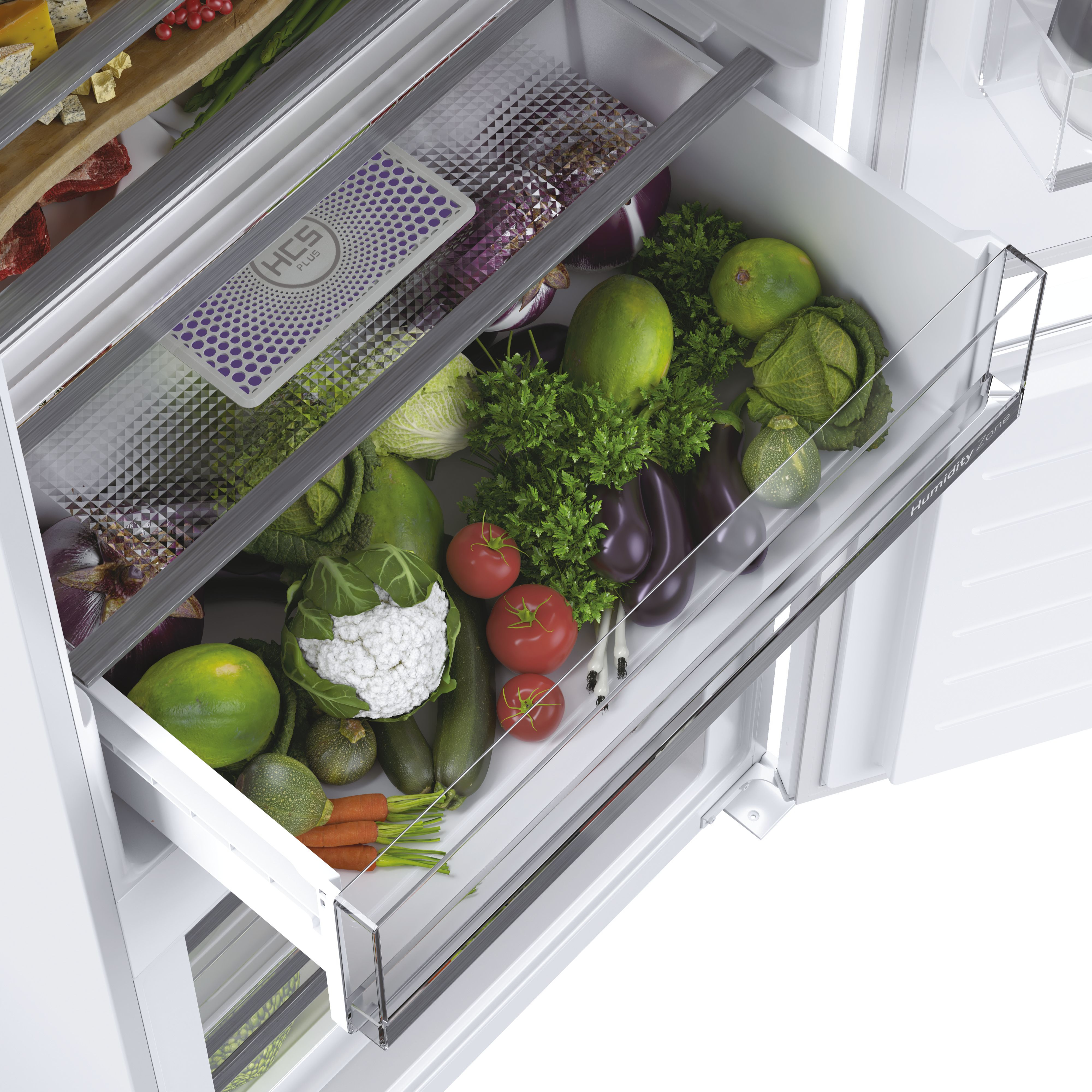 Cassetto frigo pieno di verdure fresche: pomodori, carote, cavolo e peperoni.
