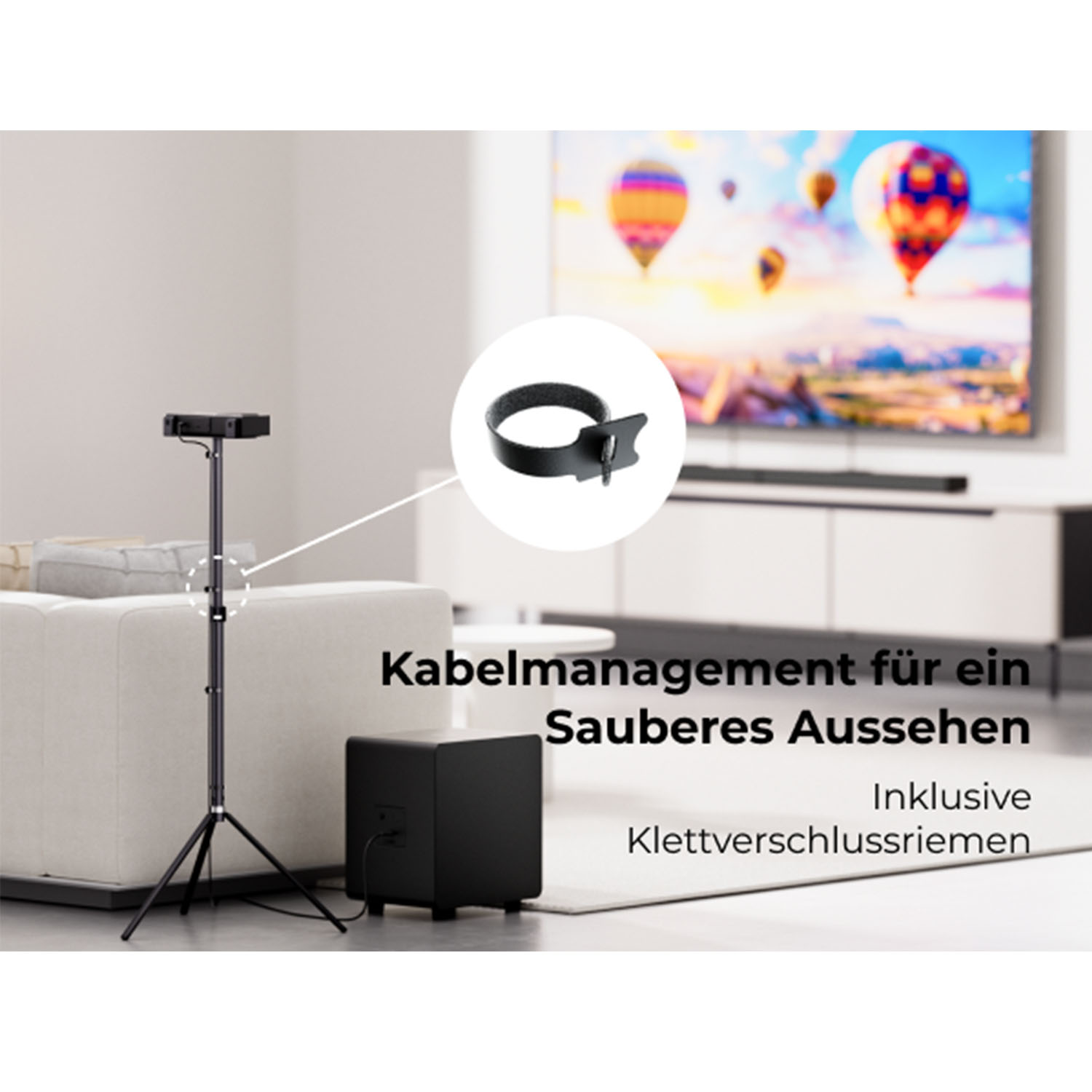 Ein schwarzer Kabel-Organizer wird hervorgehoben. Er hat einen Riemen zur Sicherung von Kabeln. Ein Fernseher und ein Subwoofer im Hintergrund.