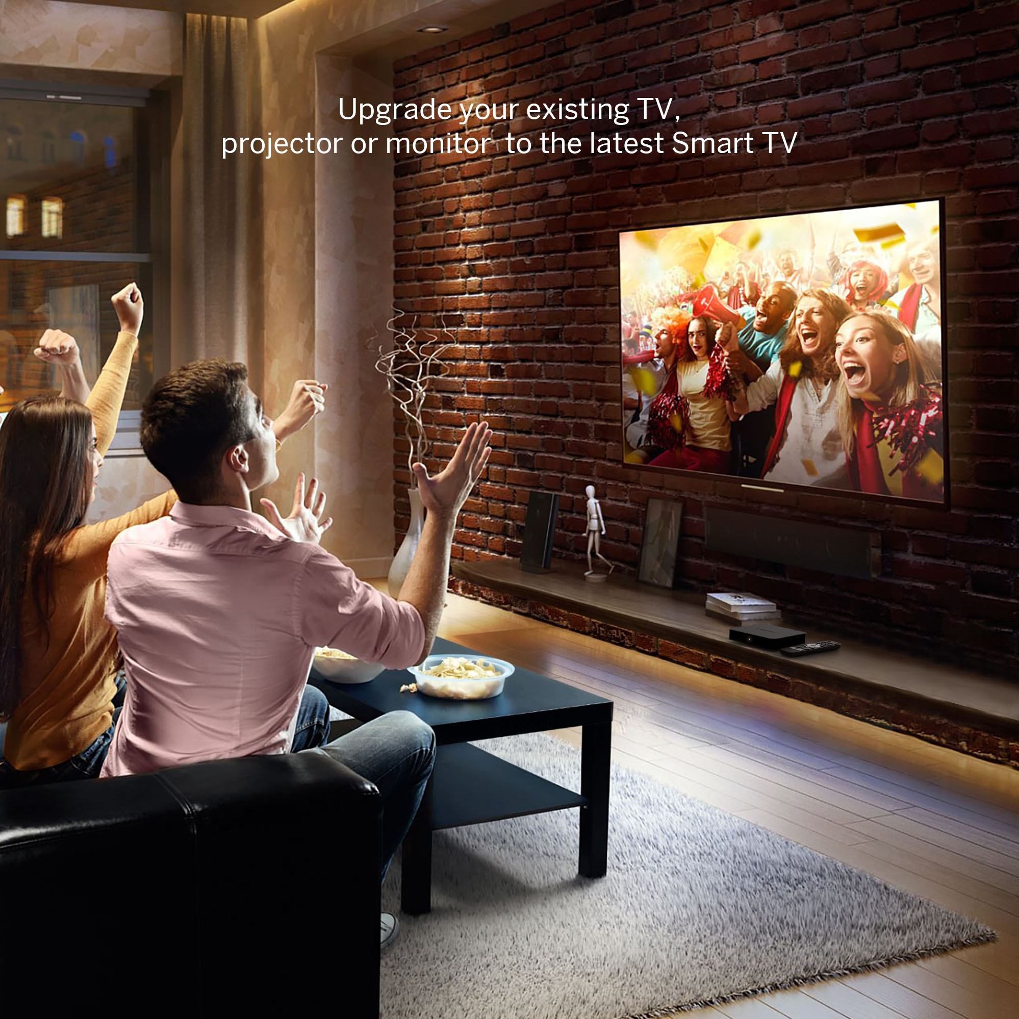 Dos personas frente a un televisor, viendo un partido con entusiasmo, sentadas en un sofá.