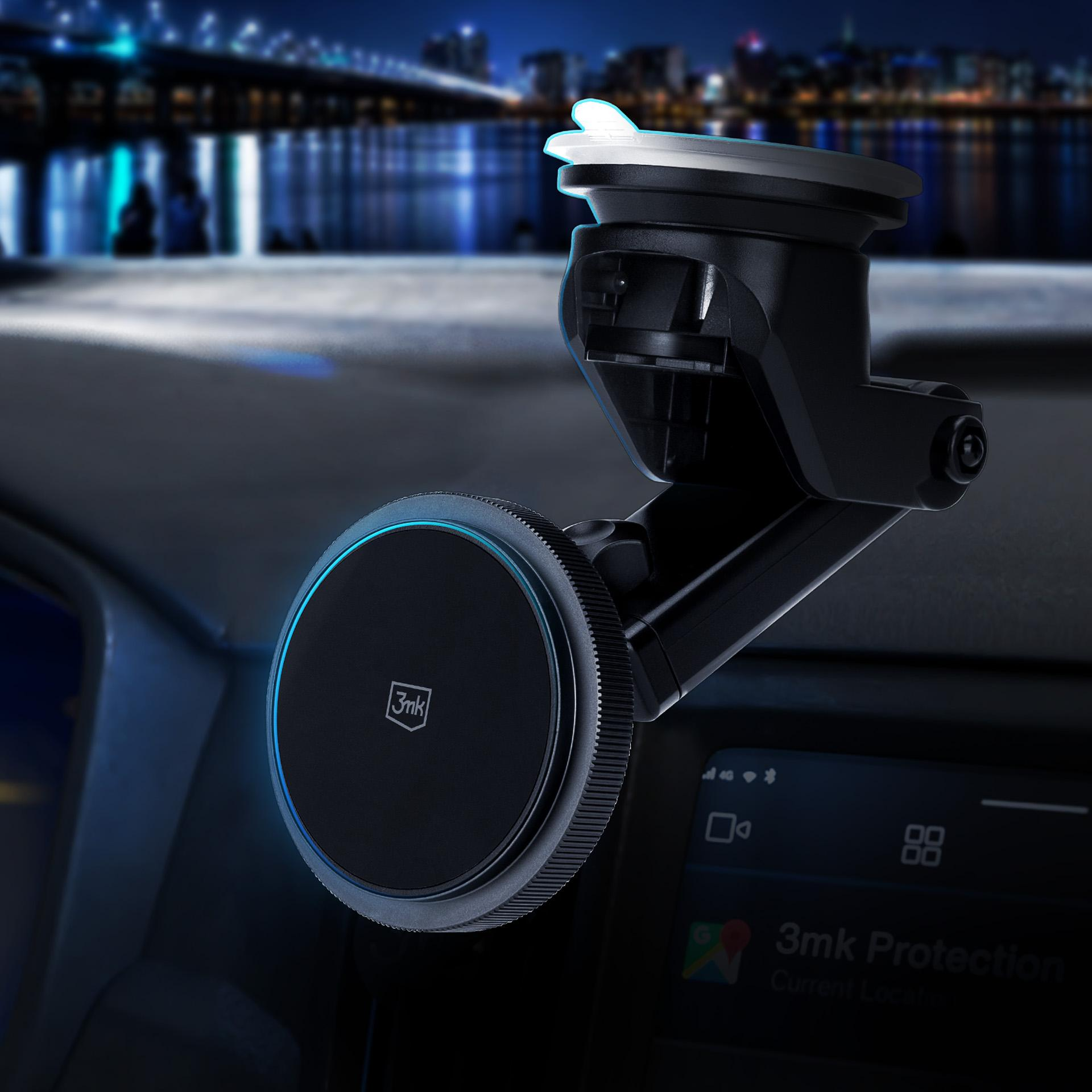 Uchwyt na telefon samochodowy zamontowany na desce rozdzielczej. Scena nocna z światłami miasta. Czarne i niebieskie tony.