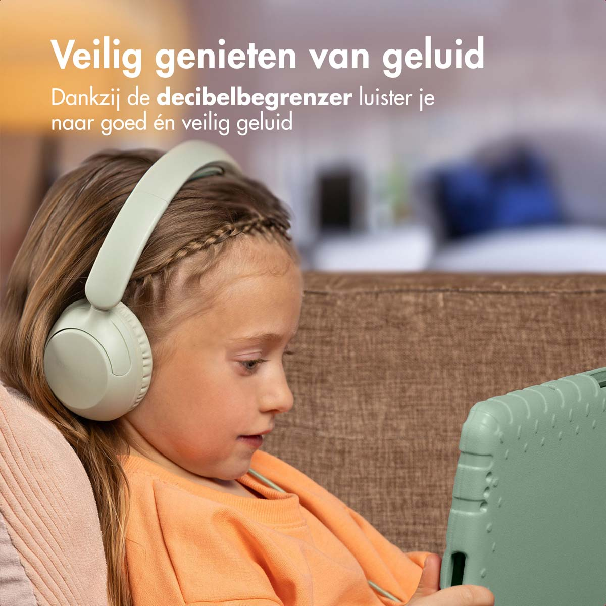 Een meisje met een mintgroene koptelefoon kijkt naar een tablet, zittend op een bank.