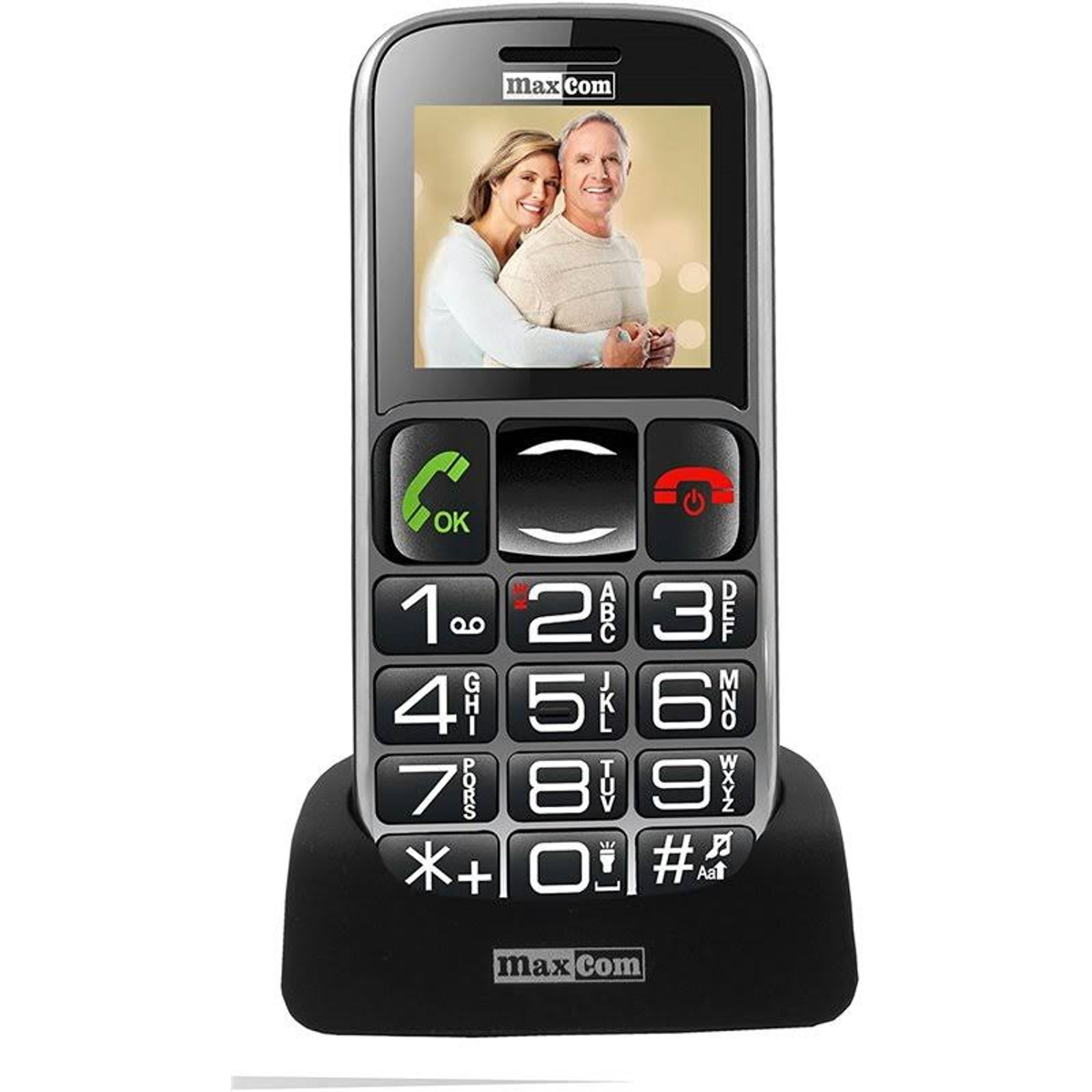 Teléfono Max Com, mostrando una pareja en la pantalla. Botones grandes y teclado blanco. Sobre base negra.