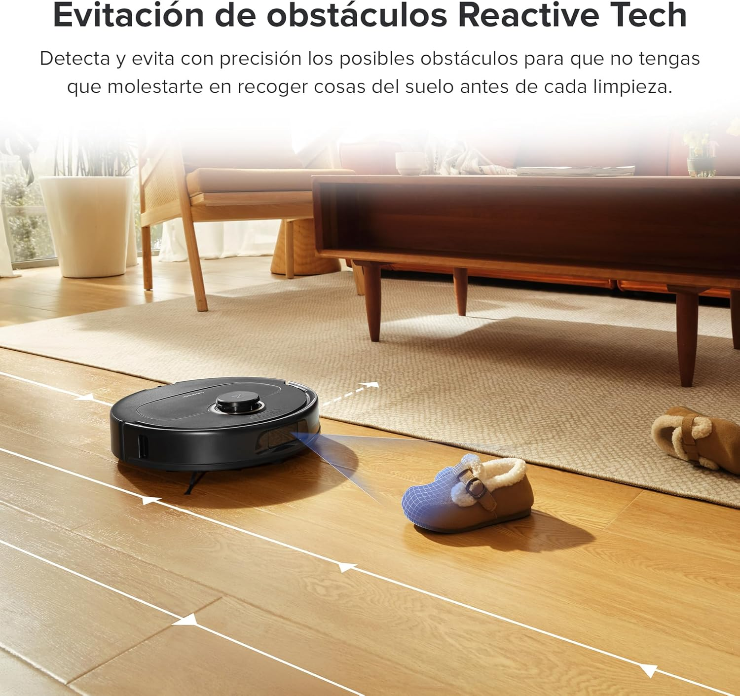 Un robot aspirador negro evita una zapatilla en un piso de madera en una sala de estar.
