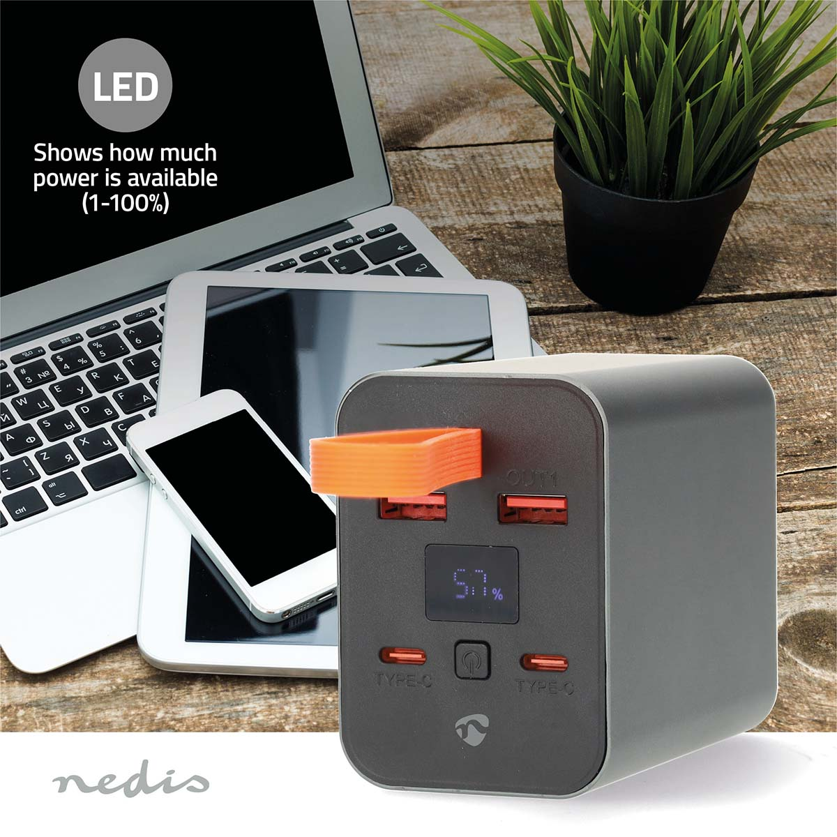 Un power bank carica un laptop, un tablet e un telefono. Il power bank è nero con una maniglia arancione, che mostra il 57% di carica.