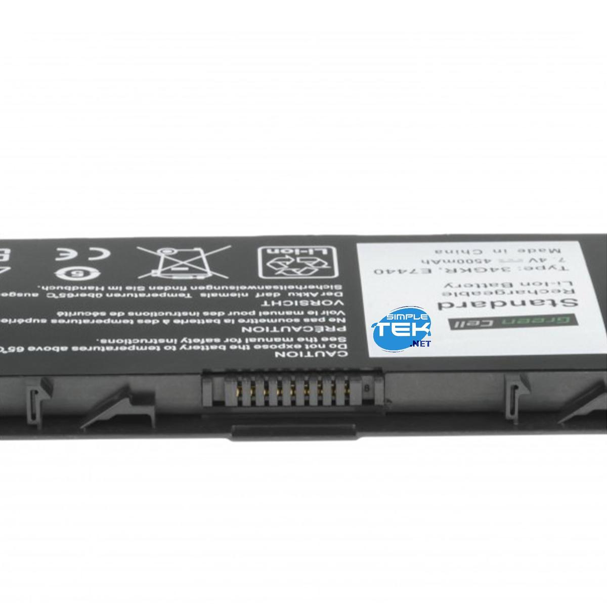 Zbliżenie czarno-zielonej baterii do laptopa. Widoczny na niej tekst i symbole.