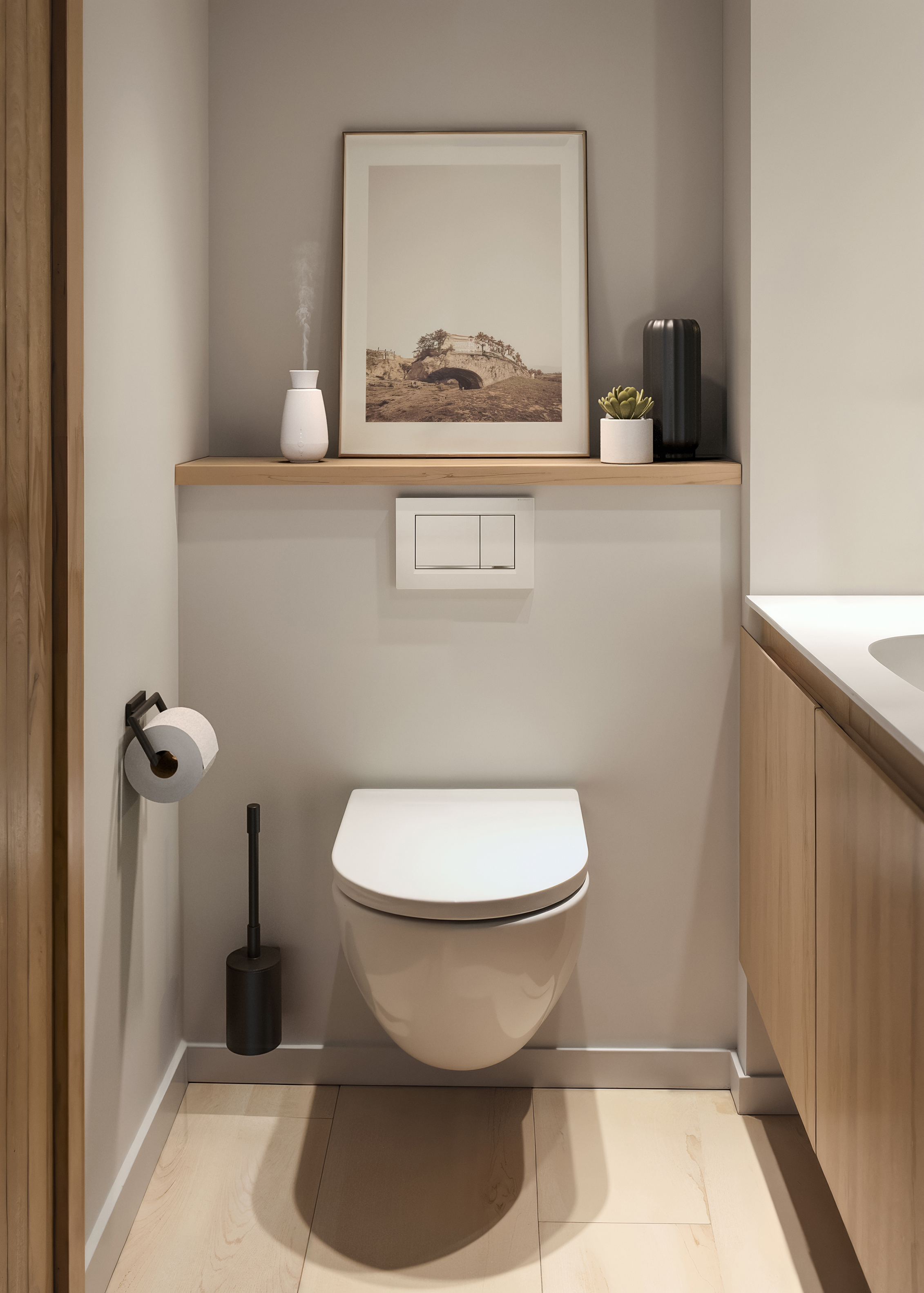 Nowoczesne wnętrze łazienki z toaletą, drewnianą szafką i oprawionym obrazem.