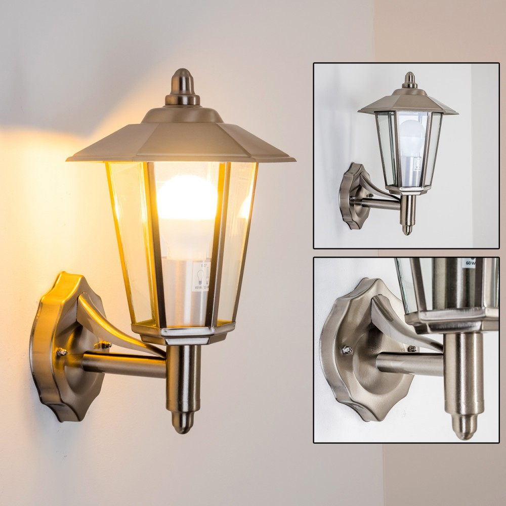 Silberne Außenwandleuchte mit Glasgehäuse und weißer Glühbirne. Sie hat einen dekorativen Sockel und einen gebogenen Arm.