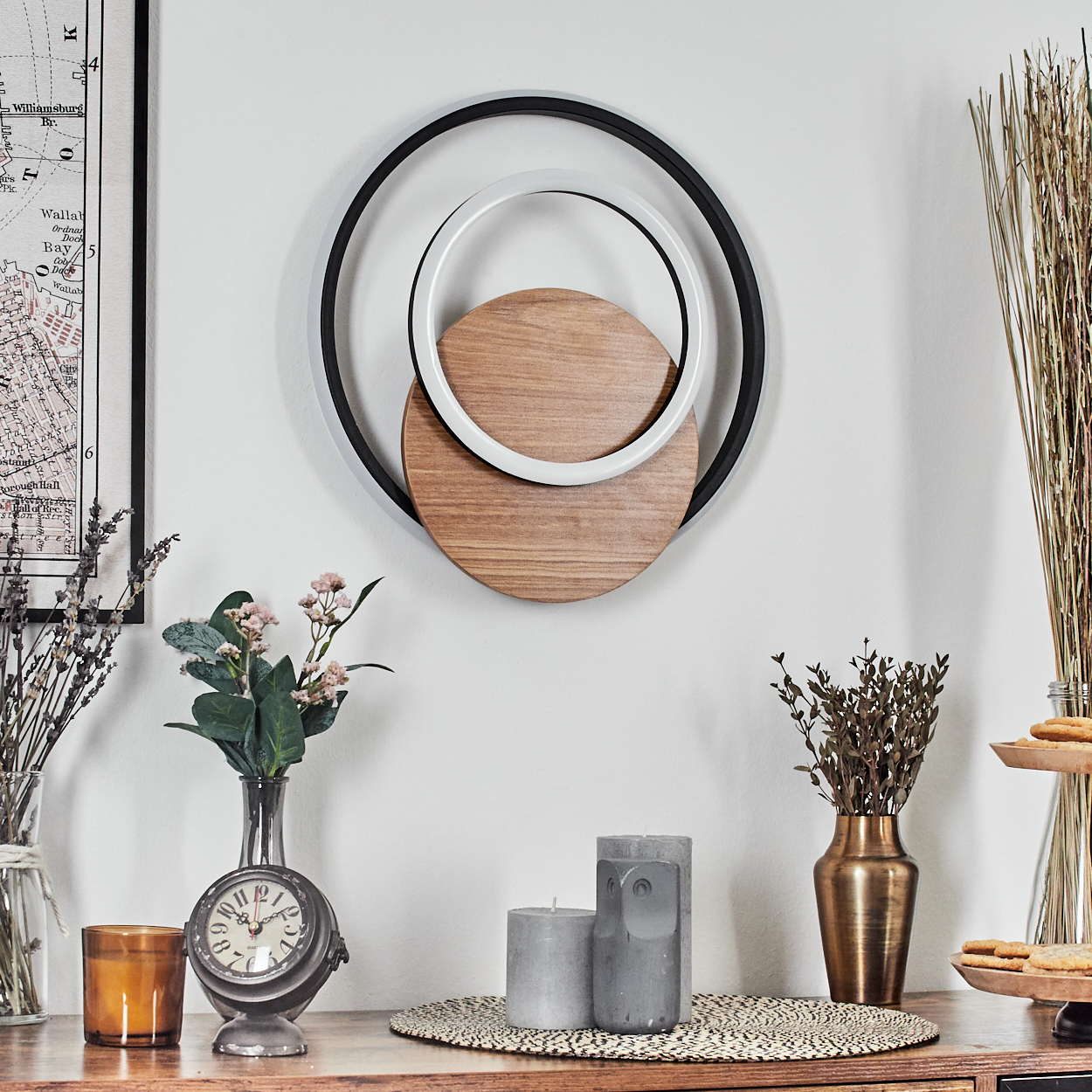 Holztisch mit Dekoration. Ein dekoratives Stück mit zwei Kreisen, einer Uhr, Kerzen und Trockenblumen.