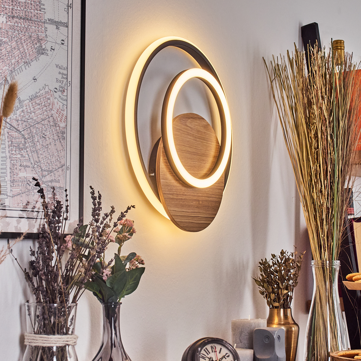 Wanddekor mit kreisförmigem Design und warmer Beleuchtung. Enthält Holz- und Weißelemente.