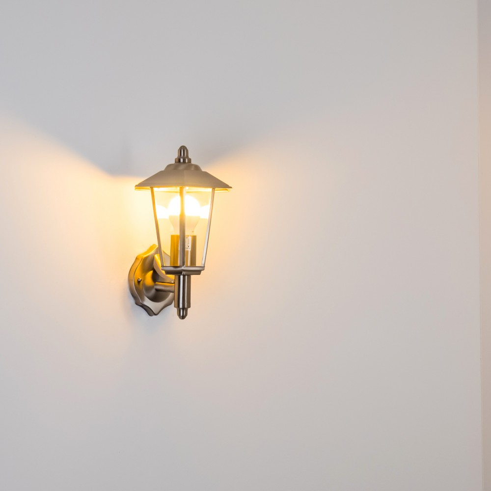 Eine Wandleuchte mit goldener Oberfläche, eine Glühbirne ist an.