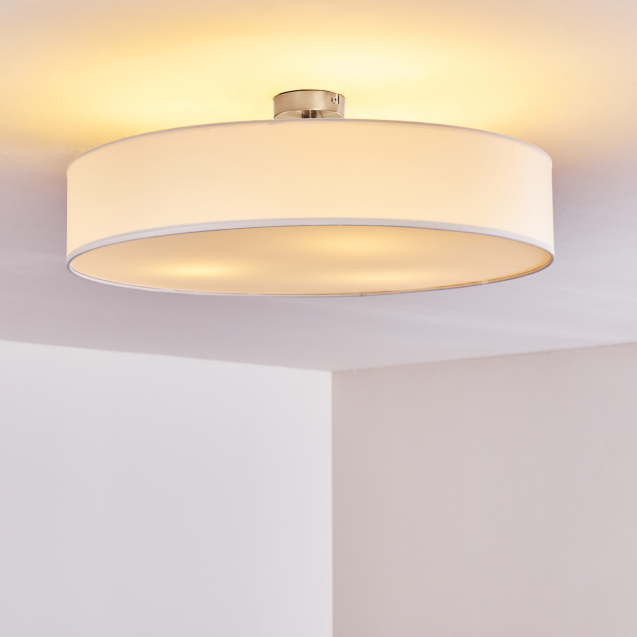 Eine runde, weiße Deckenlampe beleuchtet den Raum.
