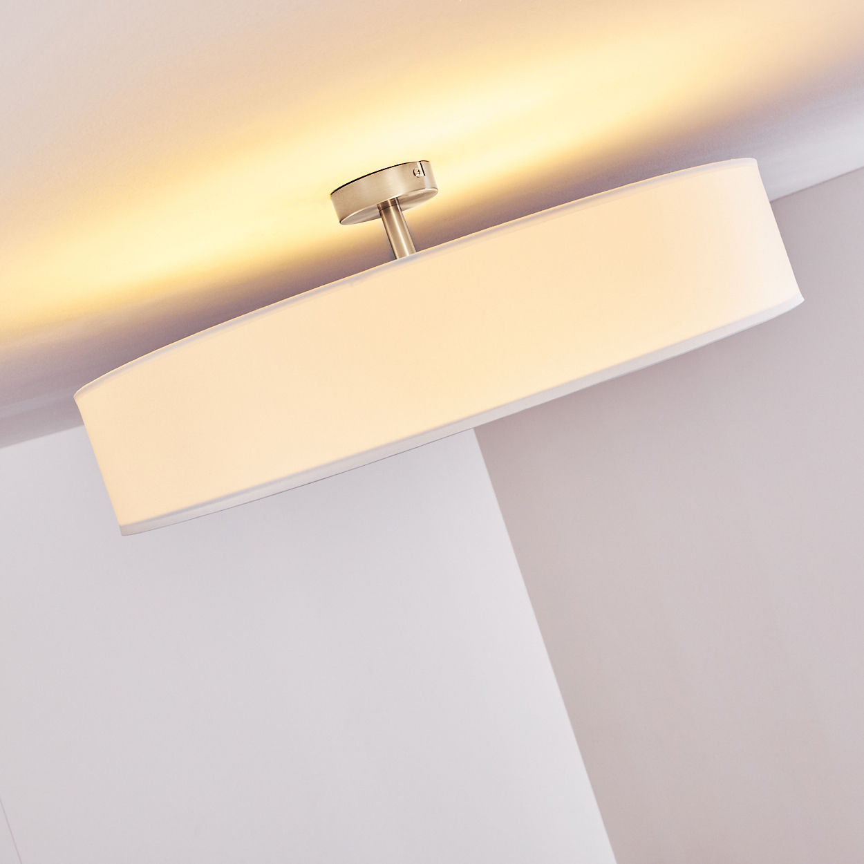 Eine weiße, rechteckige Deckenlampe ist an der Decke montiert.