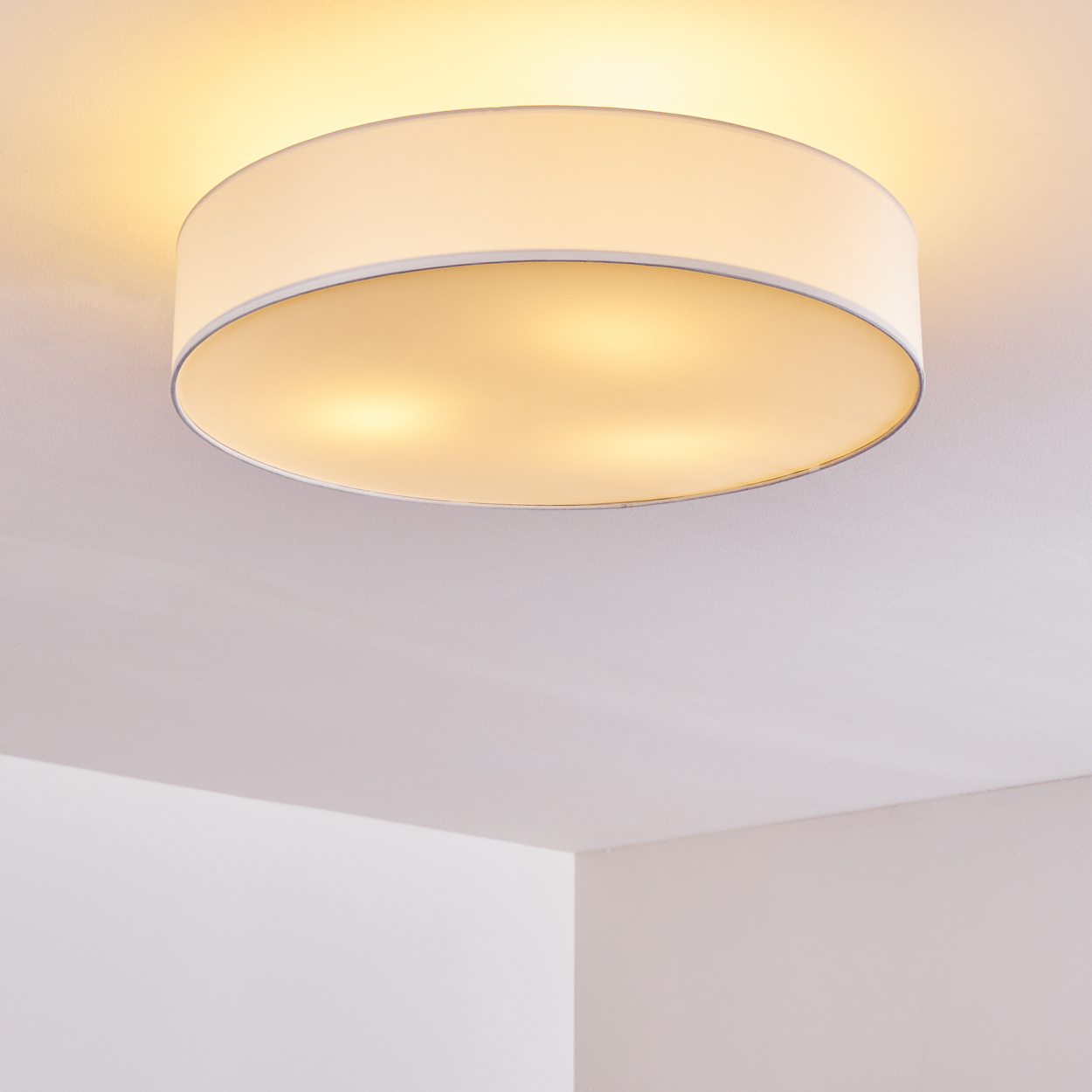 Eine weiße Deckenlampe beleuchtet den Raum, vor weißem Hintergrund.