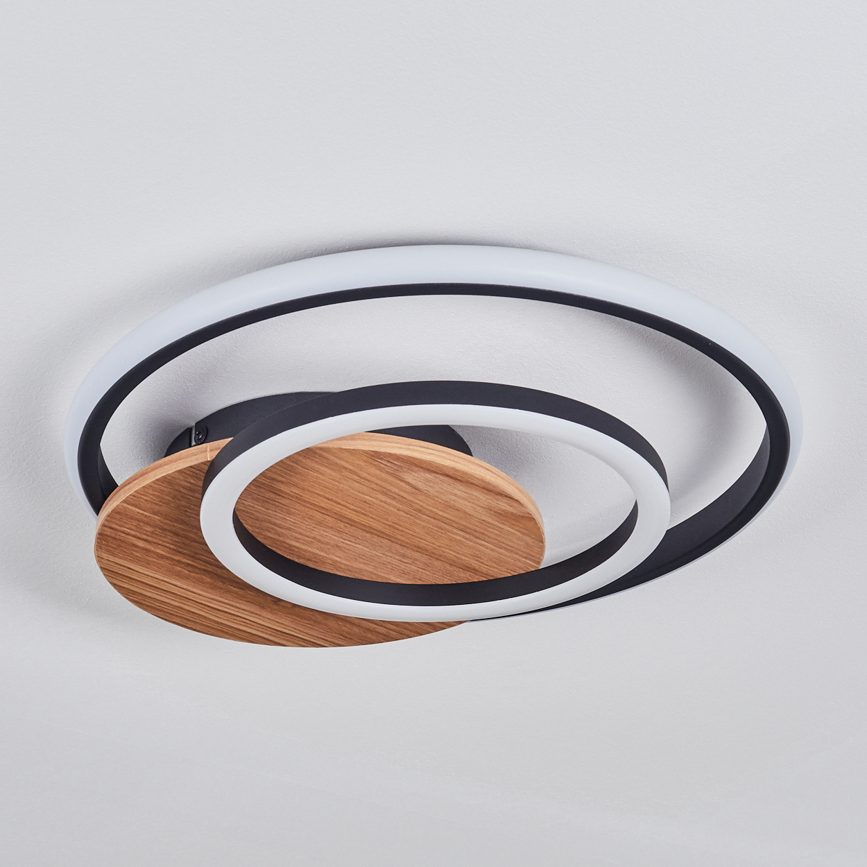 Nahaufnahme einer Deckenleuchte mit Holz- und schwarzen Kreisen.