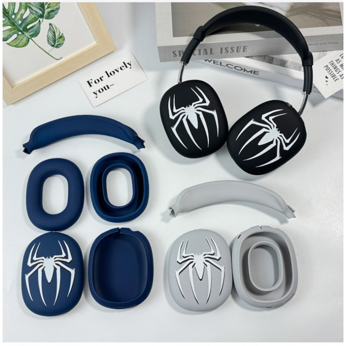 Nahaufnahme von schwarzen Kopfhörern mit weißen Spinnenlogos, mehreren Ohrmuscheln und Stirnbändern auf weißem Untergrund.