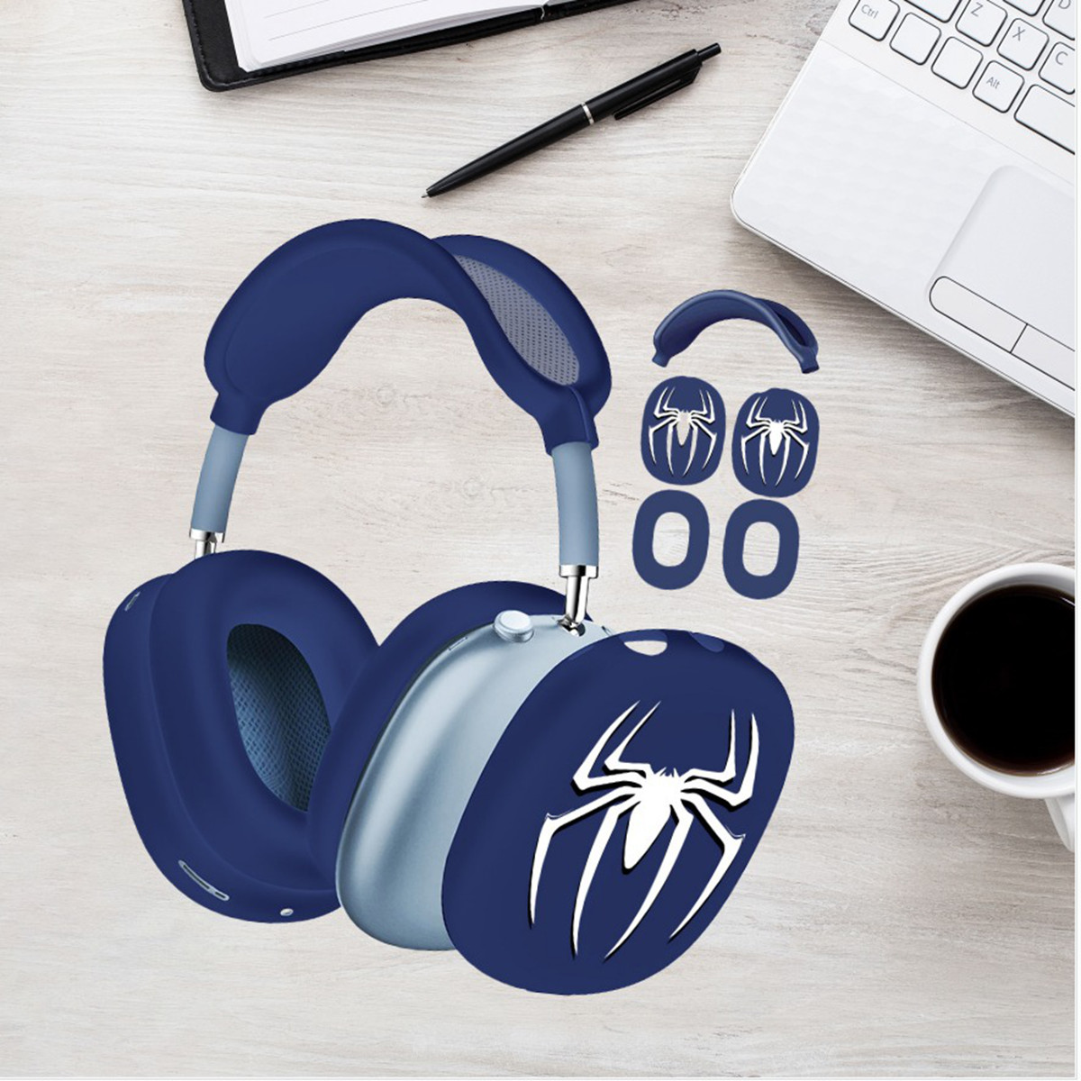 Blaue Spider-Man-Kopfhörer und Zubehör auf einem Holzschreibtisch mit Laptop und Kaffee.