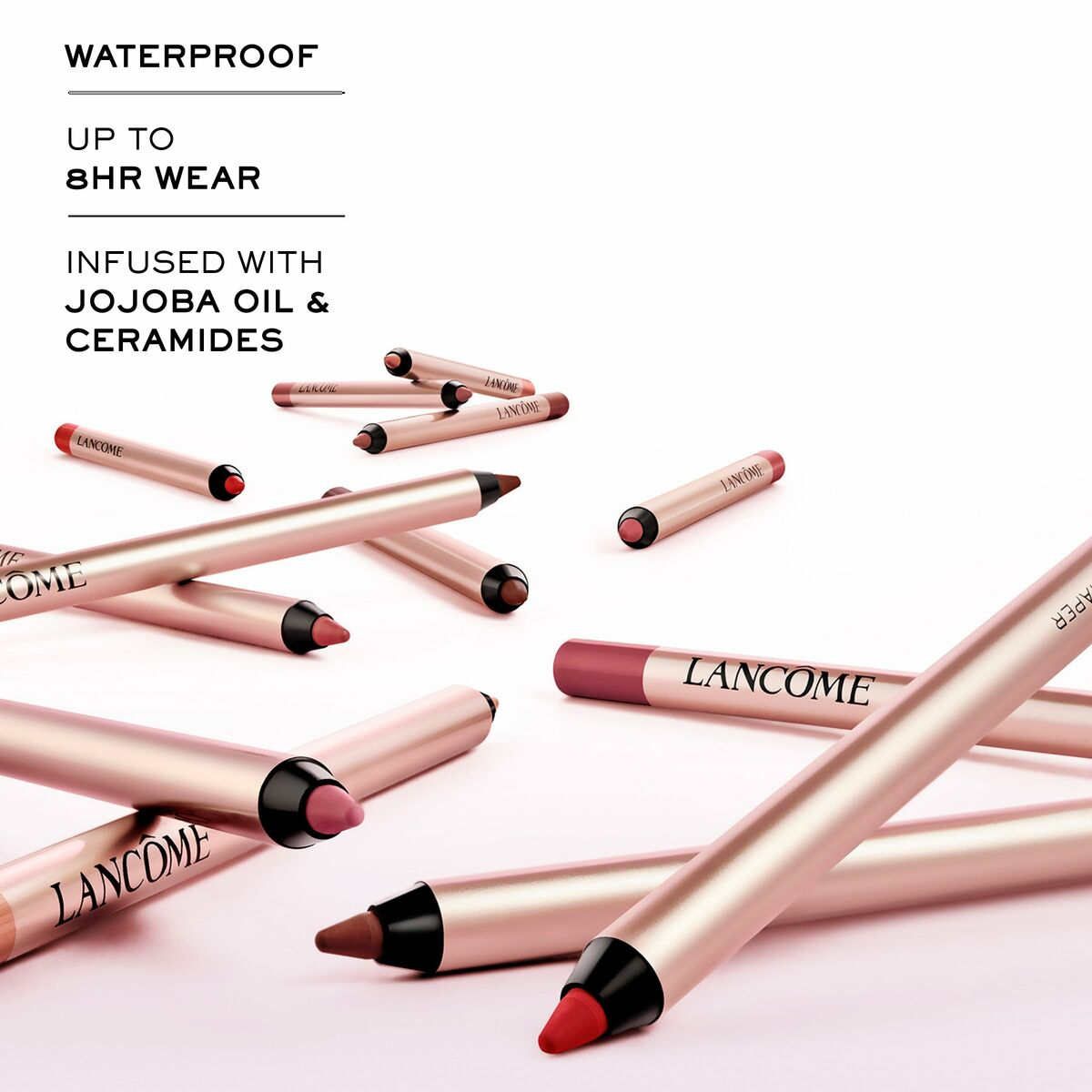 Verstreute Lancome Lippenstifte, rote und rosafarbene Farben. Text sagt wasserfest, Jojobaöl und Ceramide.