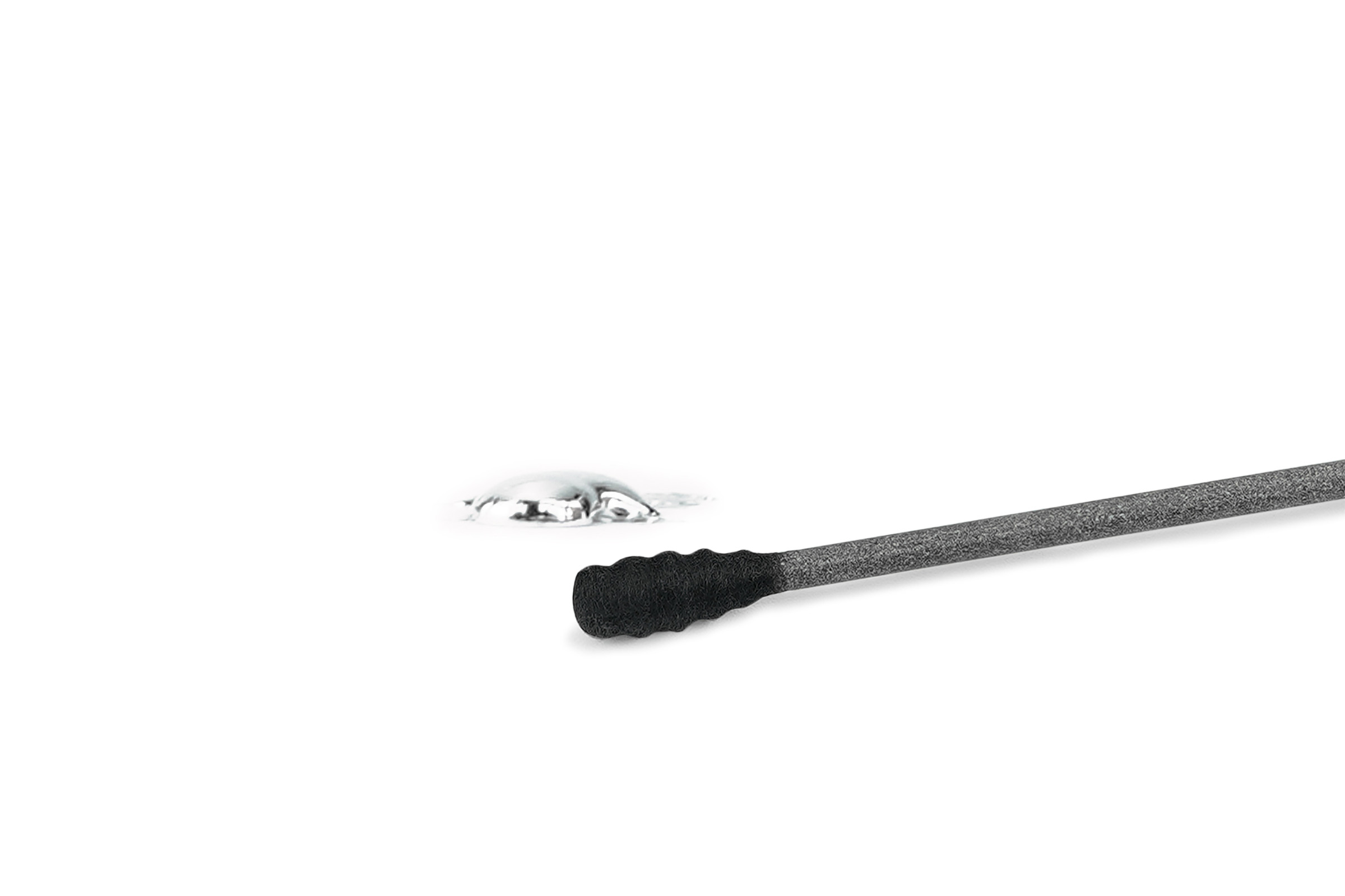 Ein Metallklecks neben einem grauen Stab mit schwarzem Ende auf Weiß.