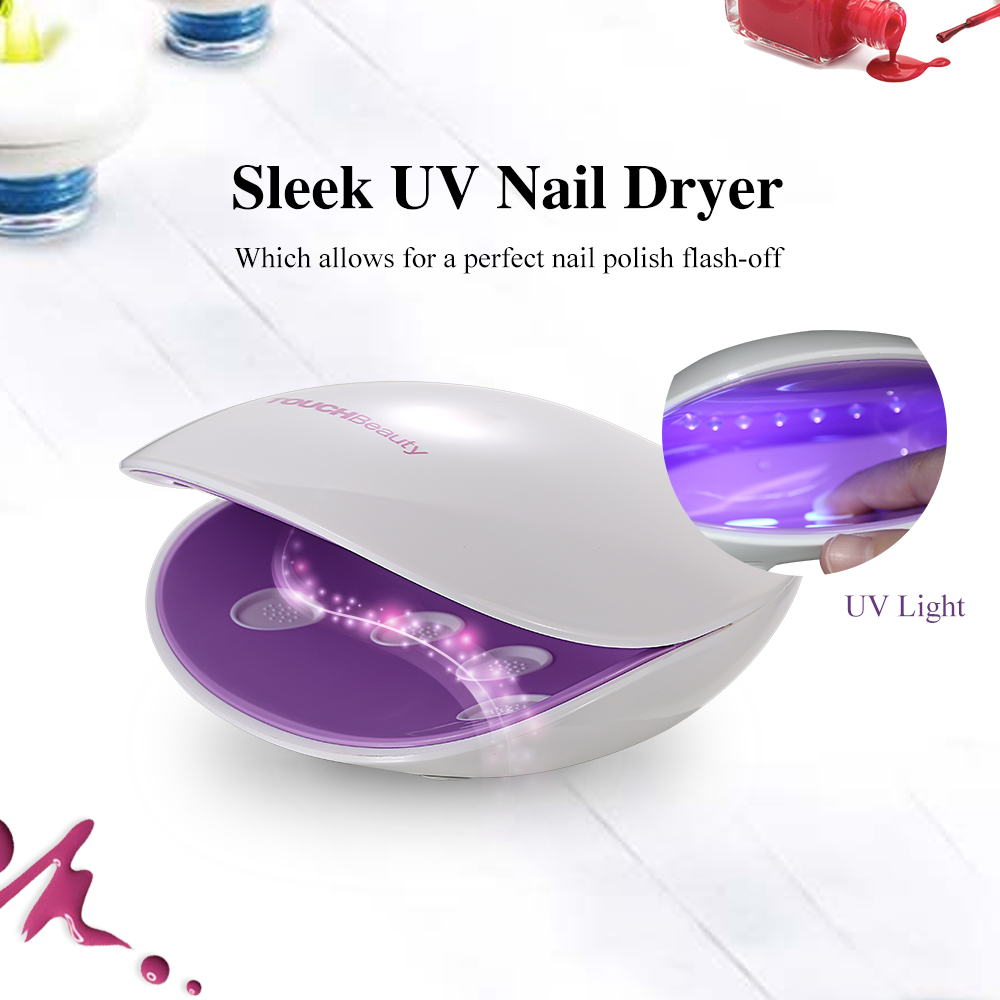 A white and purple nail dryer with UV light, surrounded by nail polish.