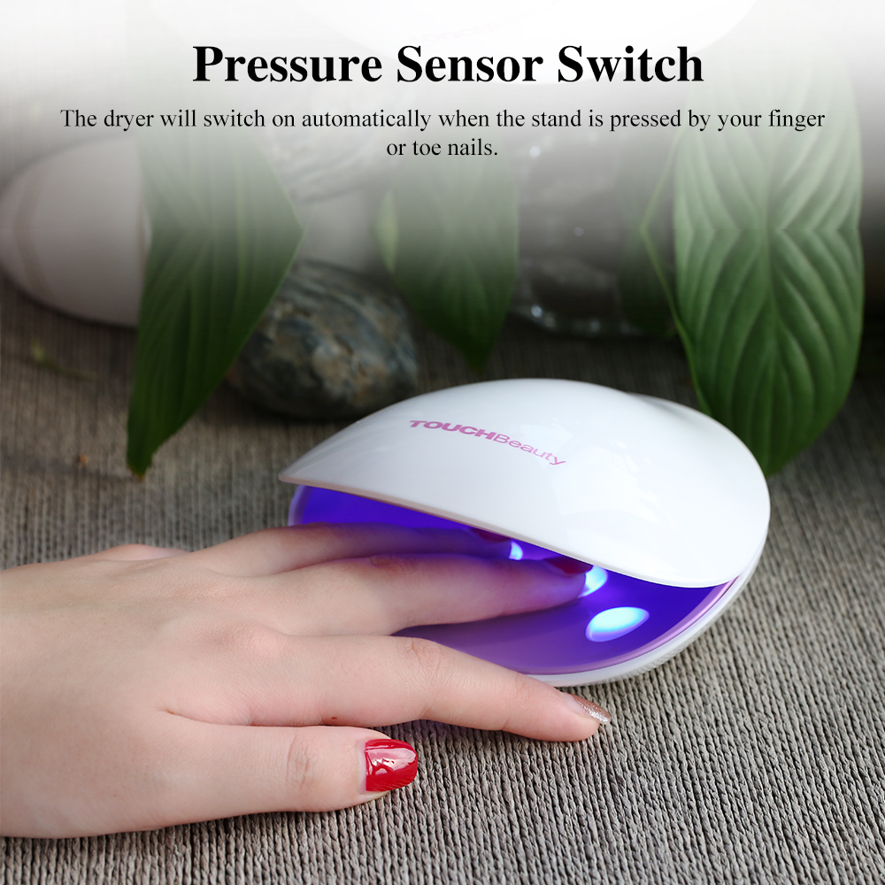 A white nail dryer with a hand inside, glowing blue light. Text reads: Pressure Sensor Switch.