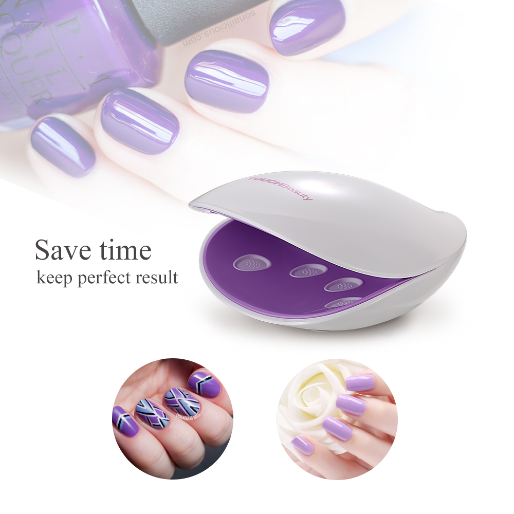 A white nail dryer with a purple interior and a woman's hand with purple nails.