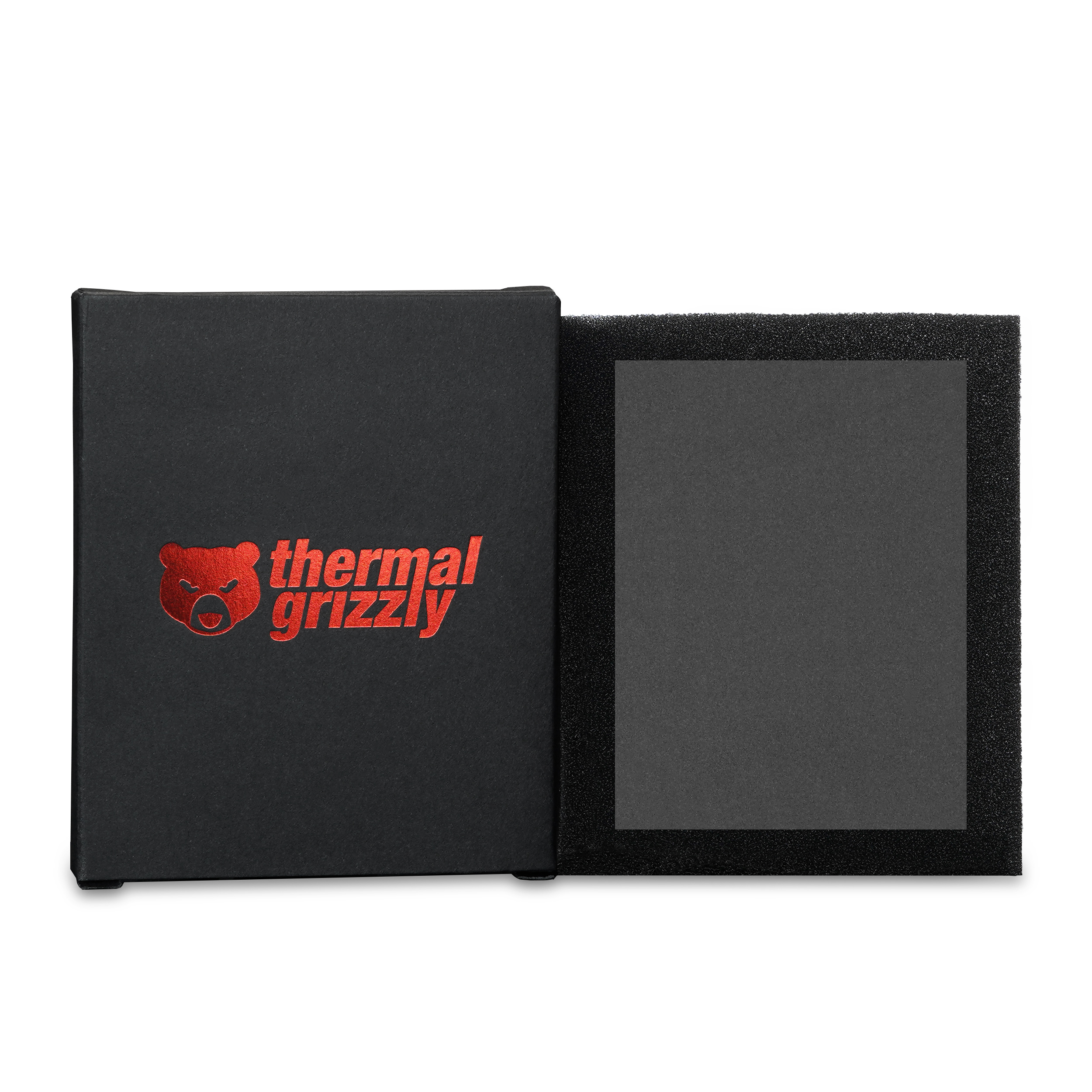 Geöffnete schwarze Schachtel mit einem schwarzen Wärmeleitpad und rotem Thermal Grizzly Logo.