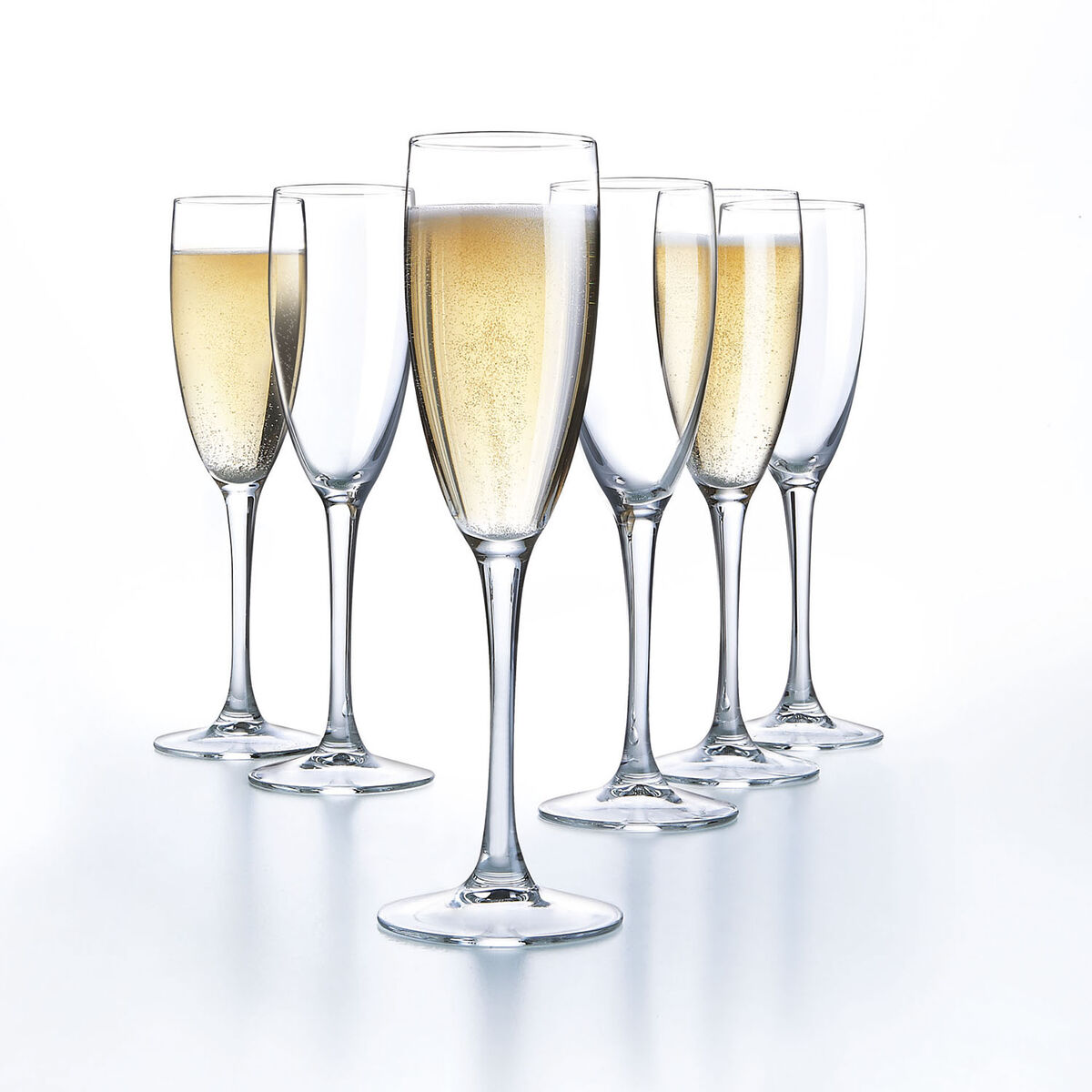 Sechs Champagnerflöten, einige mit Champagner gefüllt, stehen auf einer reflektierenden Oberfläche.