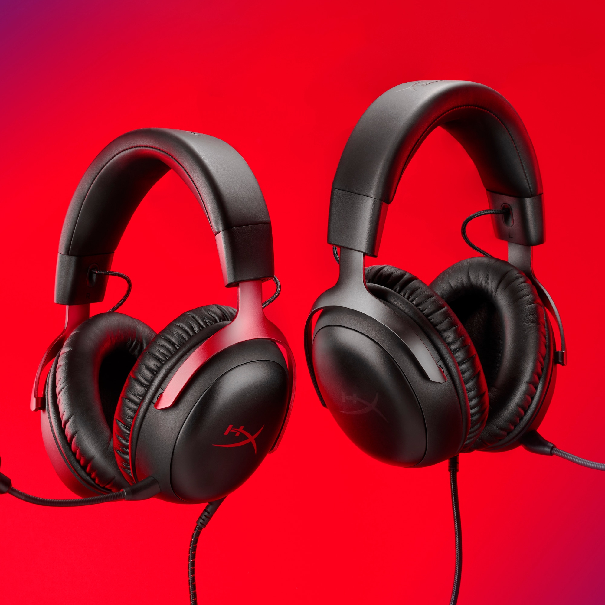 Zwei schwarze und rote HyperX-Gaming-Headsets auf rotem Hintergrund.