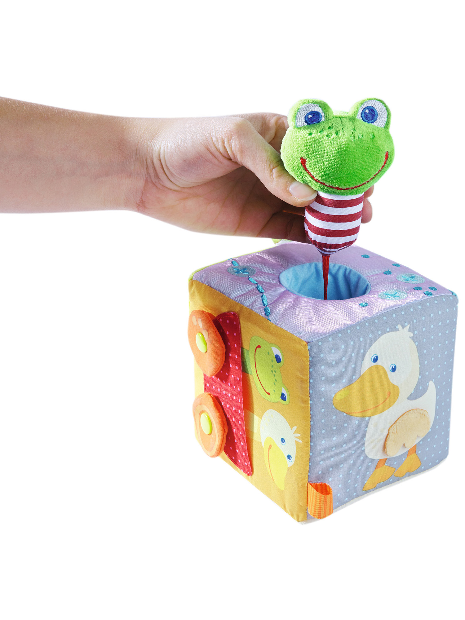 Eine Hand hält einen Froschkopf von einem Würfelspielzeug. Der Würfel hat Enten- und Autodesigns.