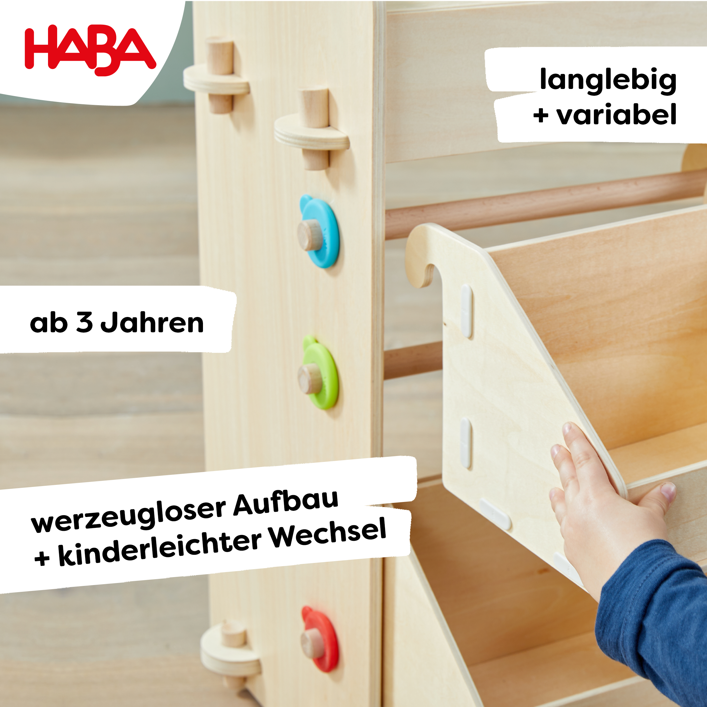 Holz-Klettergerüst mit bunten Stiften. Text: 'ab 3 Jahren'. Eine Kinderhand greift nach dem Regal.