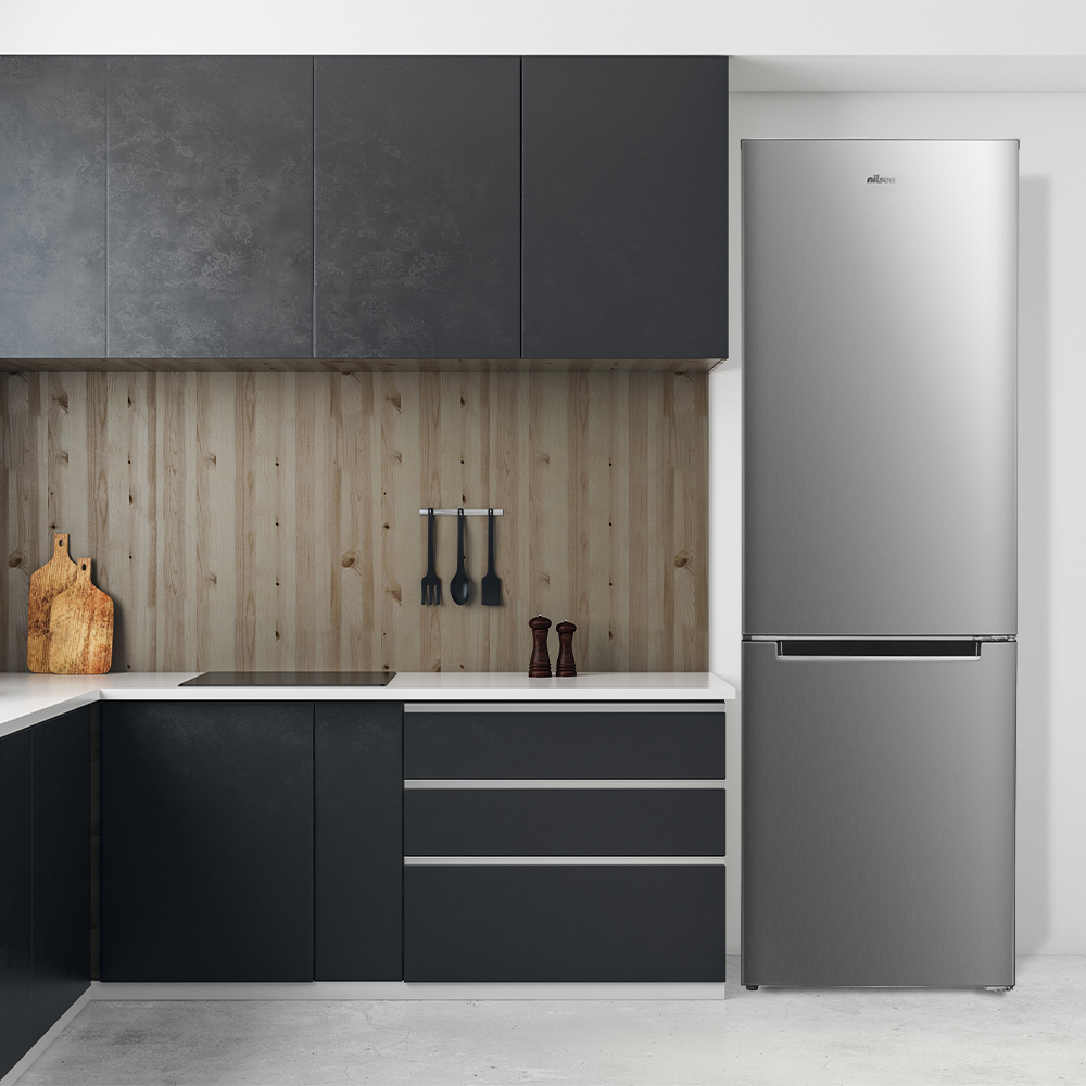 Cocina moderna con refrigerador plateado contra la pared. Armarios y encimera de madera.