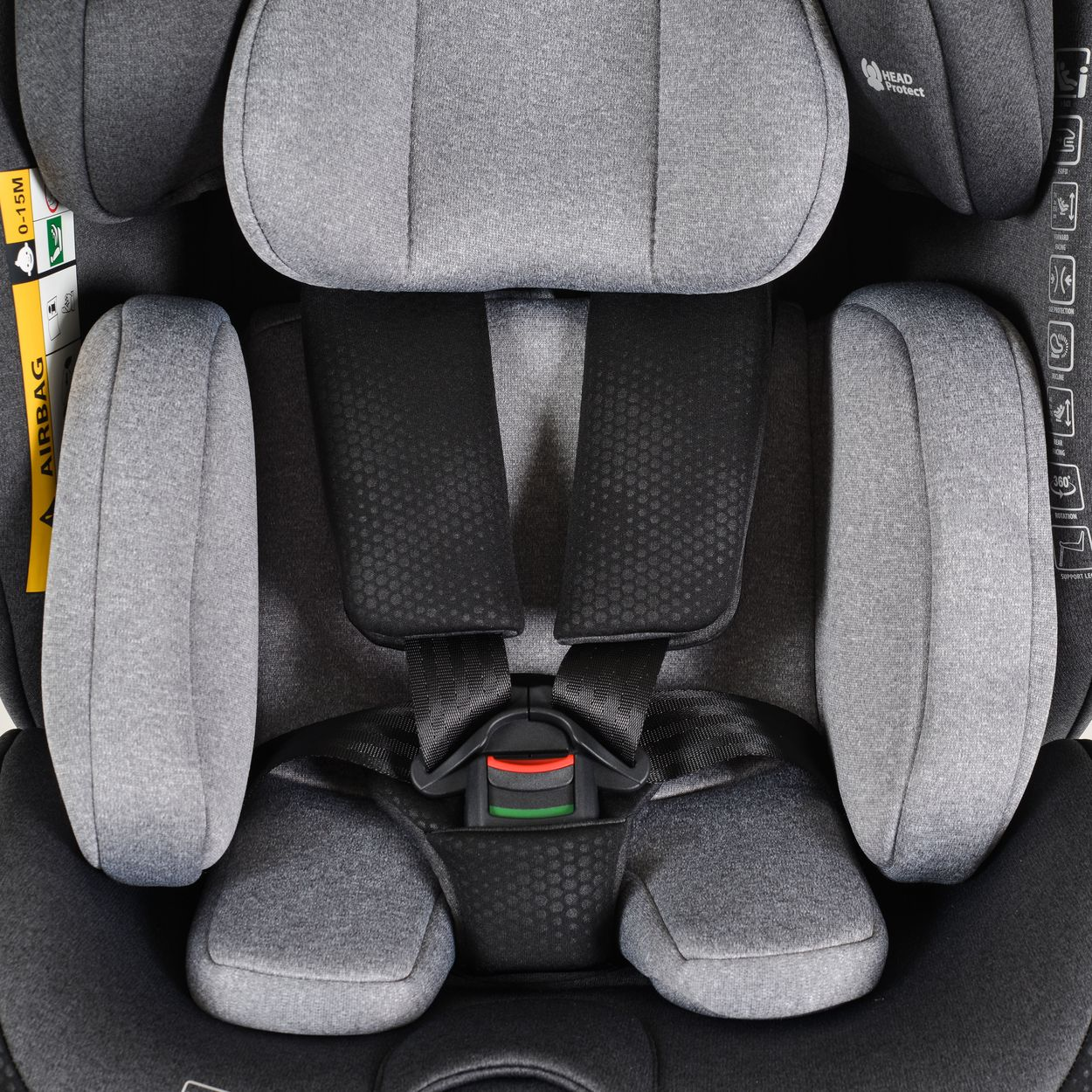 Nahaufnahme eines Autositzes mit grauer Polsterung, schwarzen Gurten und einer roten Schnalle. Mit Kopfstütze.