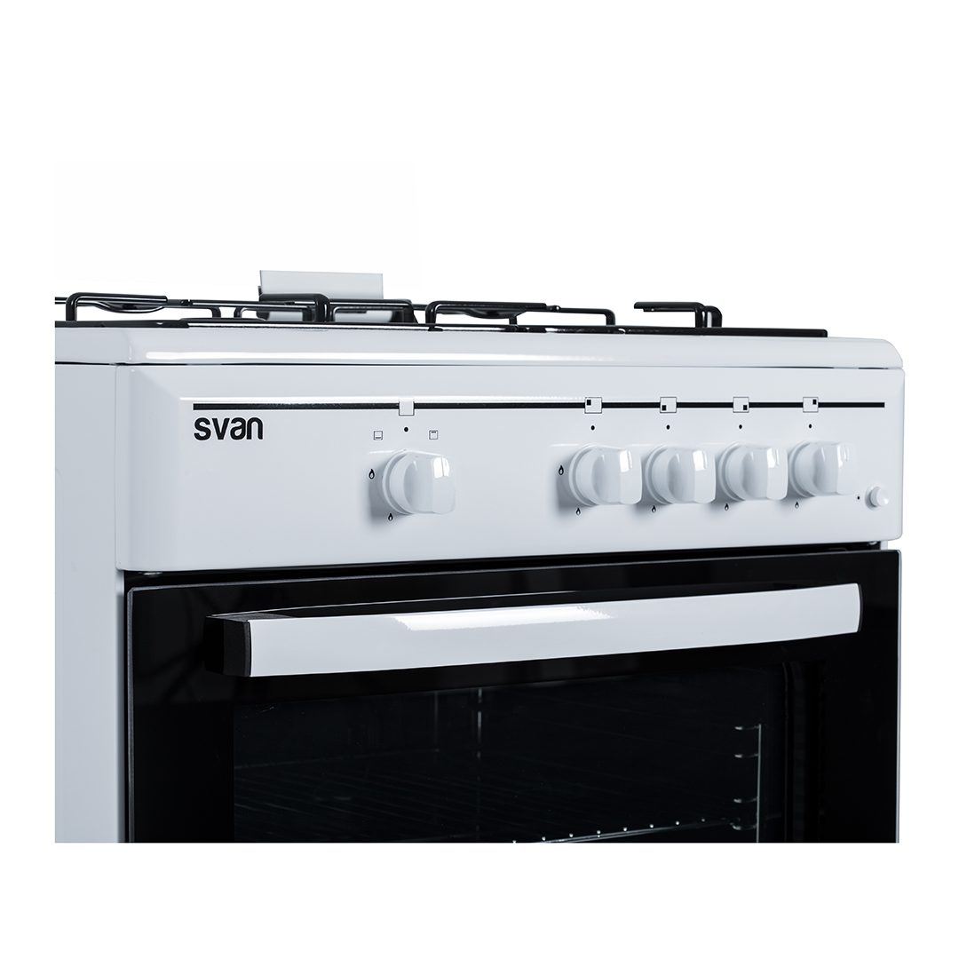 Primer plano de una estufa blanca con perillas plateadas y el nombre de la marca "svan" visible, sobre un fondo blanco.