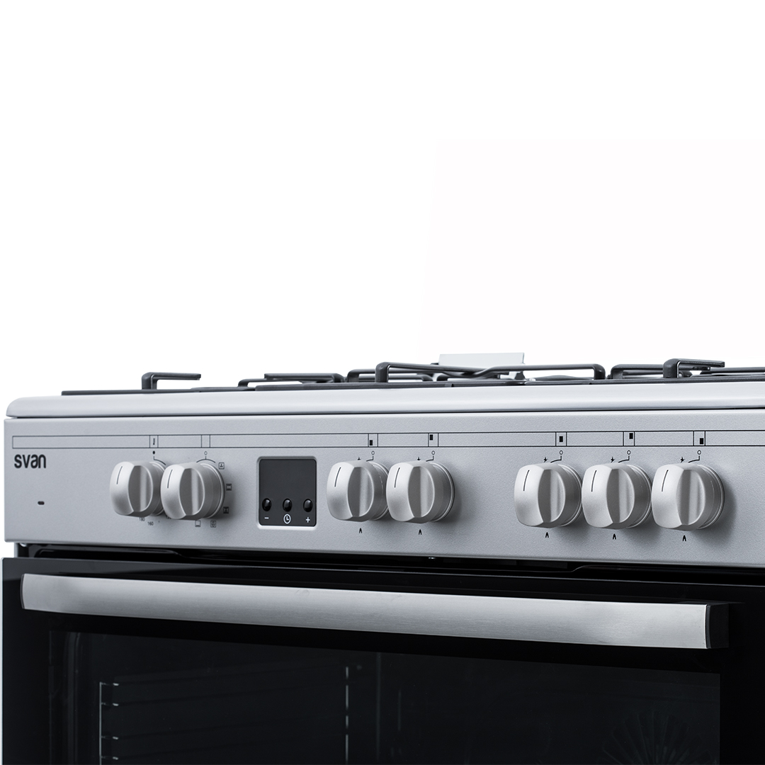 Primer plano de un horno plateado con seis perillas y una puerta de horno negra.