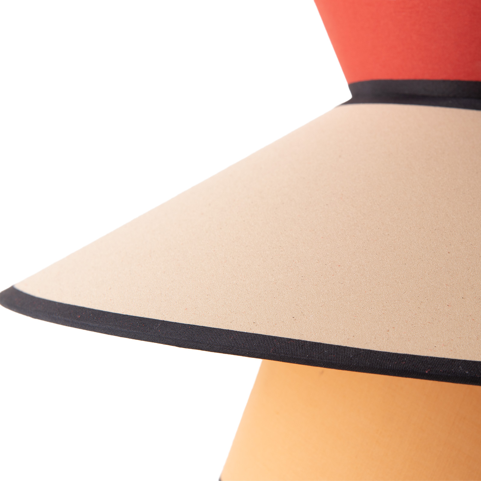 Un primer plano de una pantalla de lámpara con la parte superior roja, el medio beige y la parte inferior naranja.