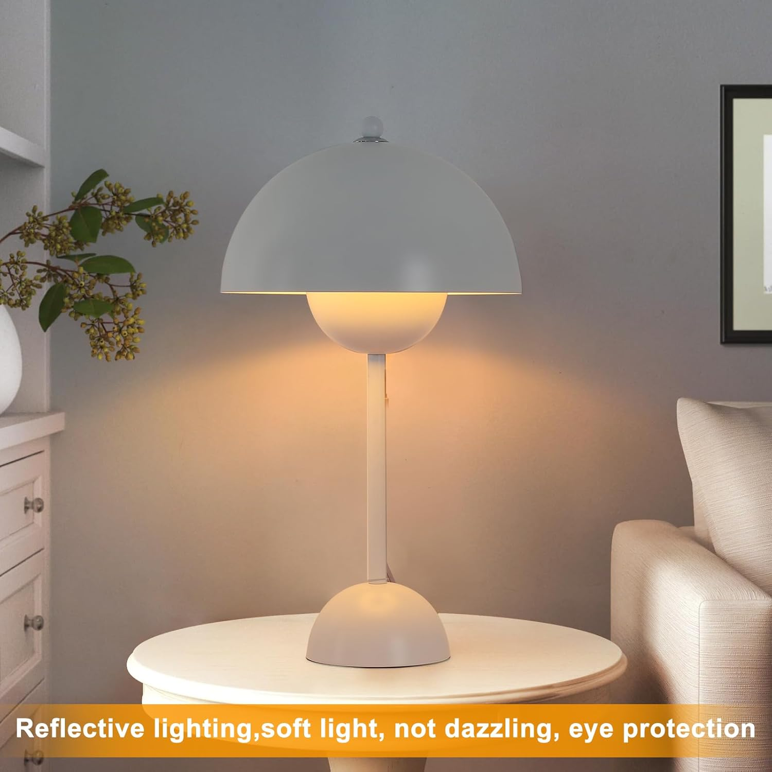 Una lámpara blanca en una mesa, reflejando luz suave en una habitación. Se ven un sofá y un pequeño armario.