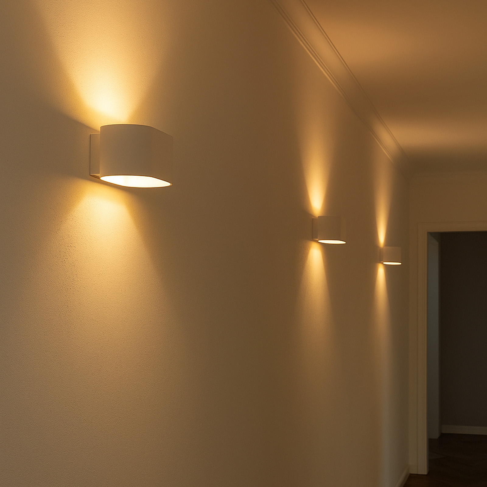 Una pared con tres lámparas de pared blancas.