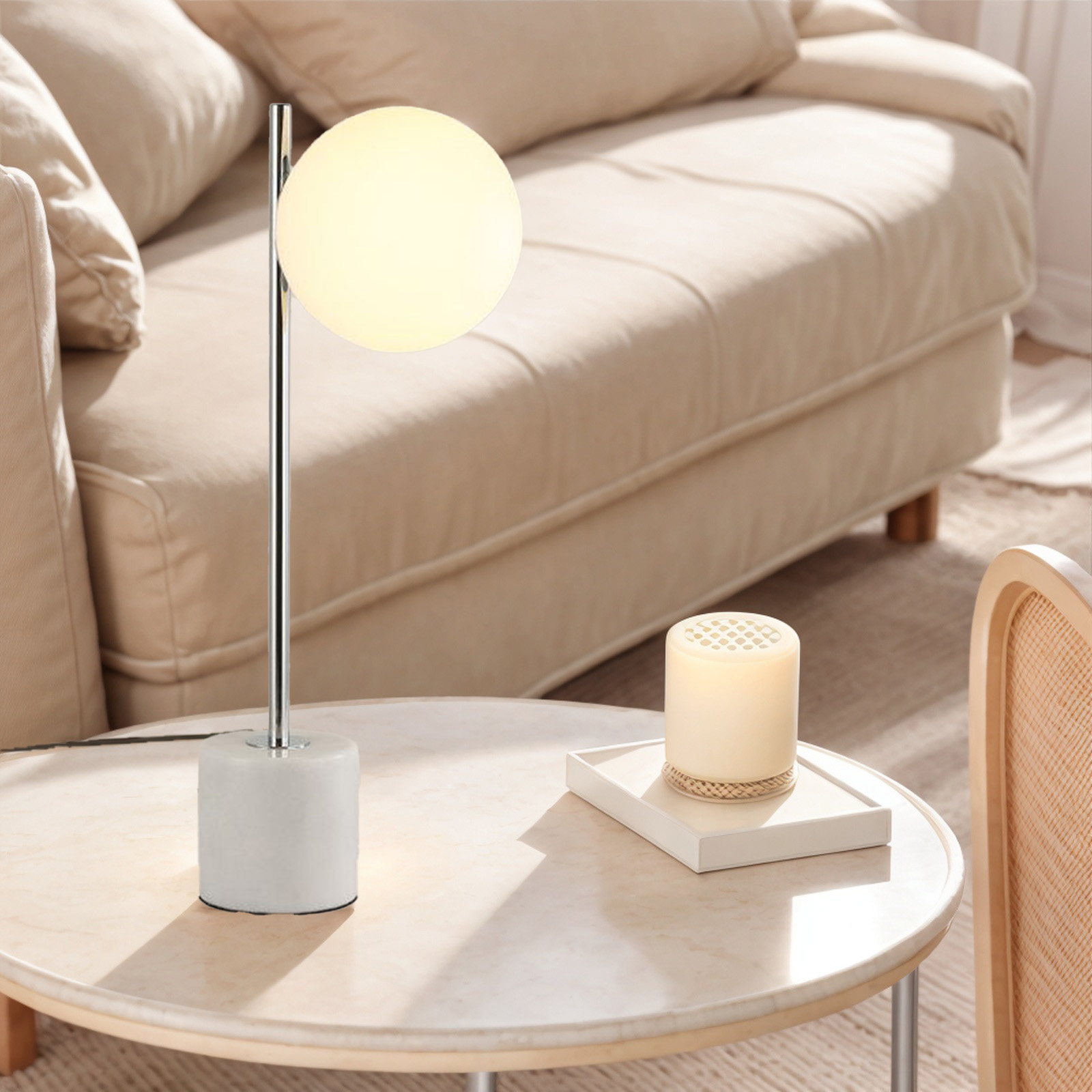 Una lámpara de mesa con una pantalla de globo blanca y una base blanca sobre una mesa.